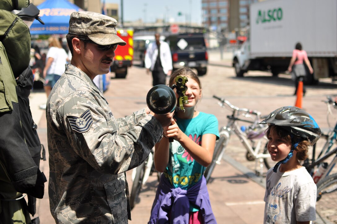 Tech Sgt. Kyle Spalding, 914 Civil Engineer Squadron, Explosive Ordnance Technician, shows a visitor some of the equipment he would be responsible for at the Buffalo and Erie County Naval and Military Park, July 25, 2014. Spalding was showcasing the 914 CES/EOD mission for Air Force Salute to Service Week. (U.S.photo by Staff Sgt. Stephanie Sawyer) 