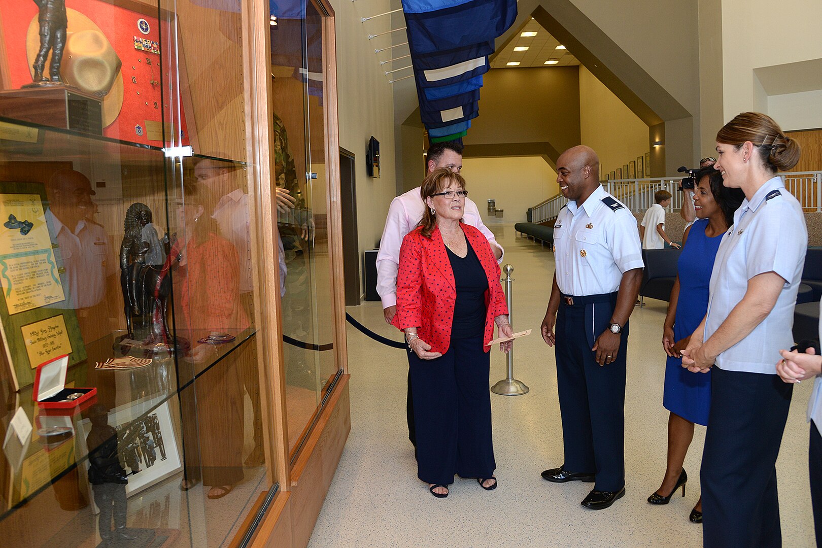 Marsha Pfingston (left) talks to Col. Trent Edwards, 37th Training commander; Edwards’ wife Vanessa; and Col. Michele Edmondson, 737th Training Group commander, about the exhibit in the new Recruit/Family In-processing and Information Center at Joint Base San Antonio-Lackland, Texas July 30, 2014 that honors her late husband, 10th Chief Master Sergeant of the Air Force Gary Pfingston. (U.S. Air Force Photo by Benjamin Faske/Released)