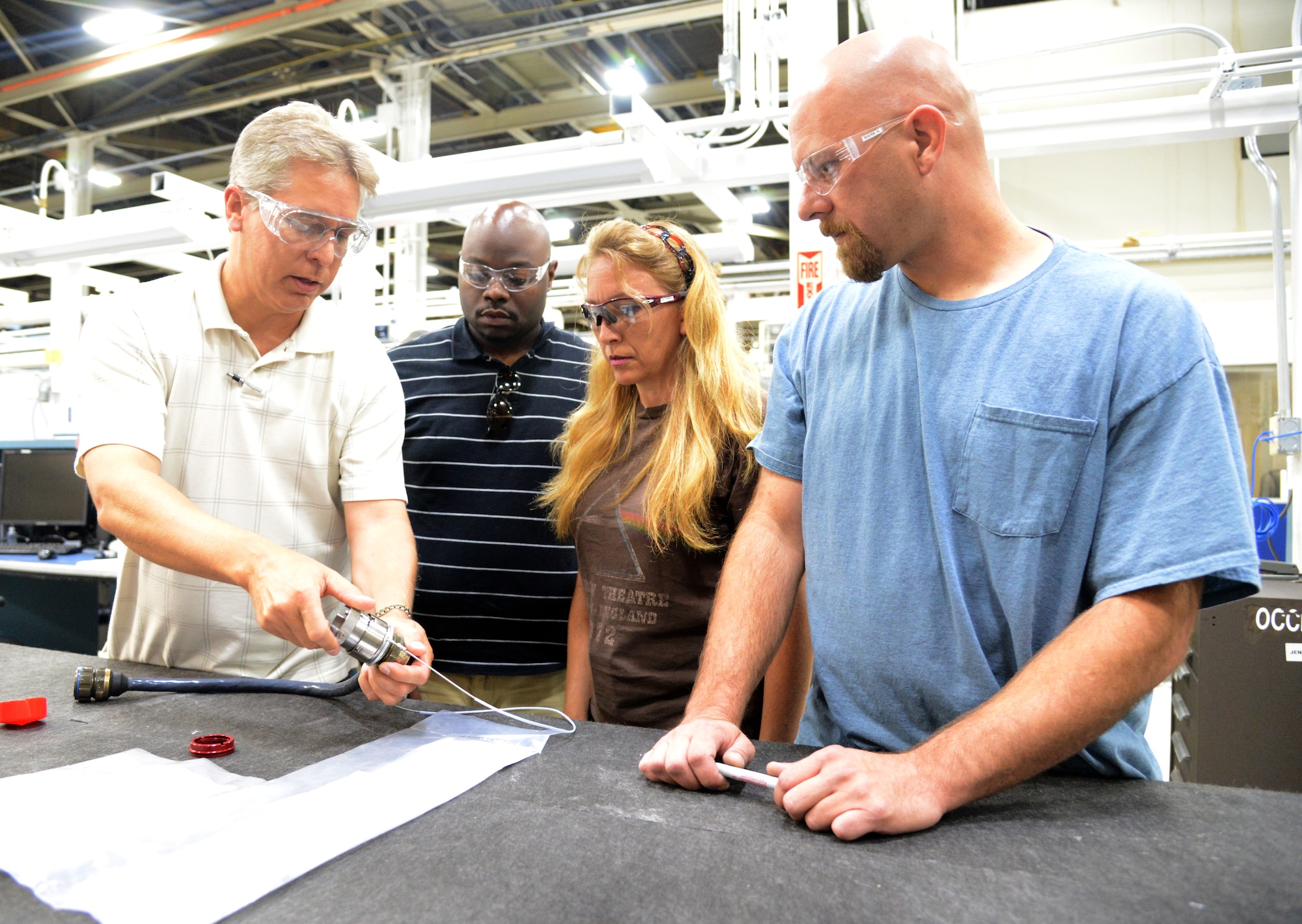Engineers Roderick Diehl and David Jones III from the 424th Supply Chain Management Squadron review a new weapons umbilical design for use on the B-1B Rotary Launcher with maintenance technicians Rhonda White and Mark Norrell, both with the 552nd Commodities Maintenance Squadron. (Air Force photo by Kelly White)