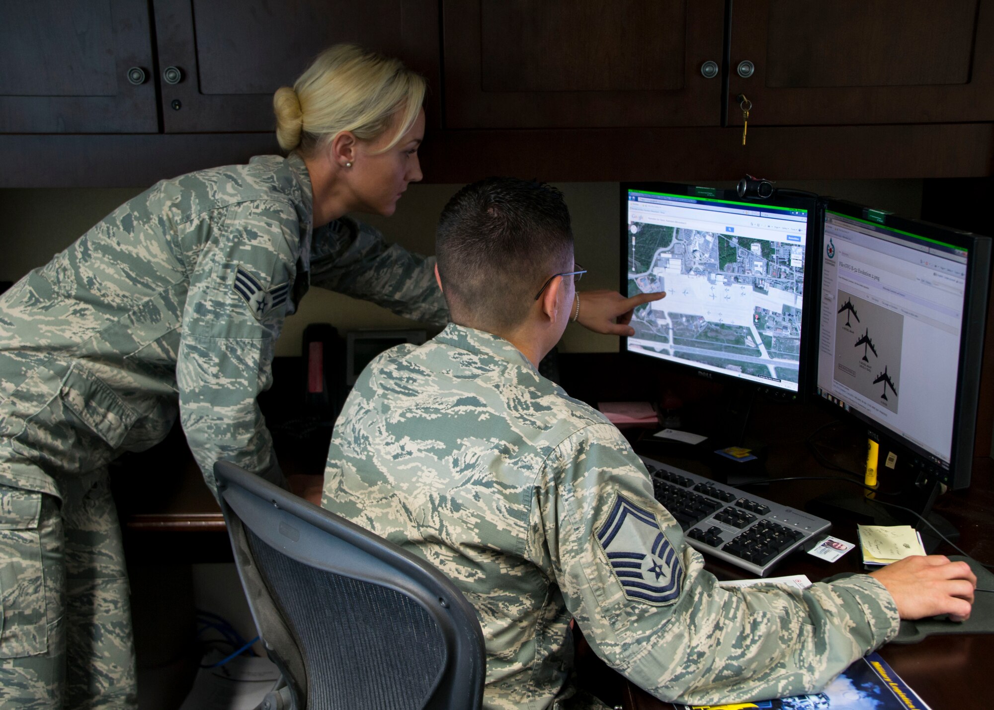 Senior Airman Shabree Heasell and Senior Master Sgt. Ryan Thuyns, both United States Air Forces in Europe and Air Forces Africa, look at images on a computer July 29, 2014 at Ramstein Air Base, Germany. Heasell was recently named one of the 12 Outstanding Airmen of the Year. As an imagery analyst, Heasell developed primary and alternate secret service routes, which secured the visits of not only President Obama but also 223 other personnel. (Courtesy Photo)