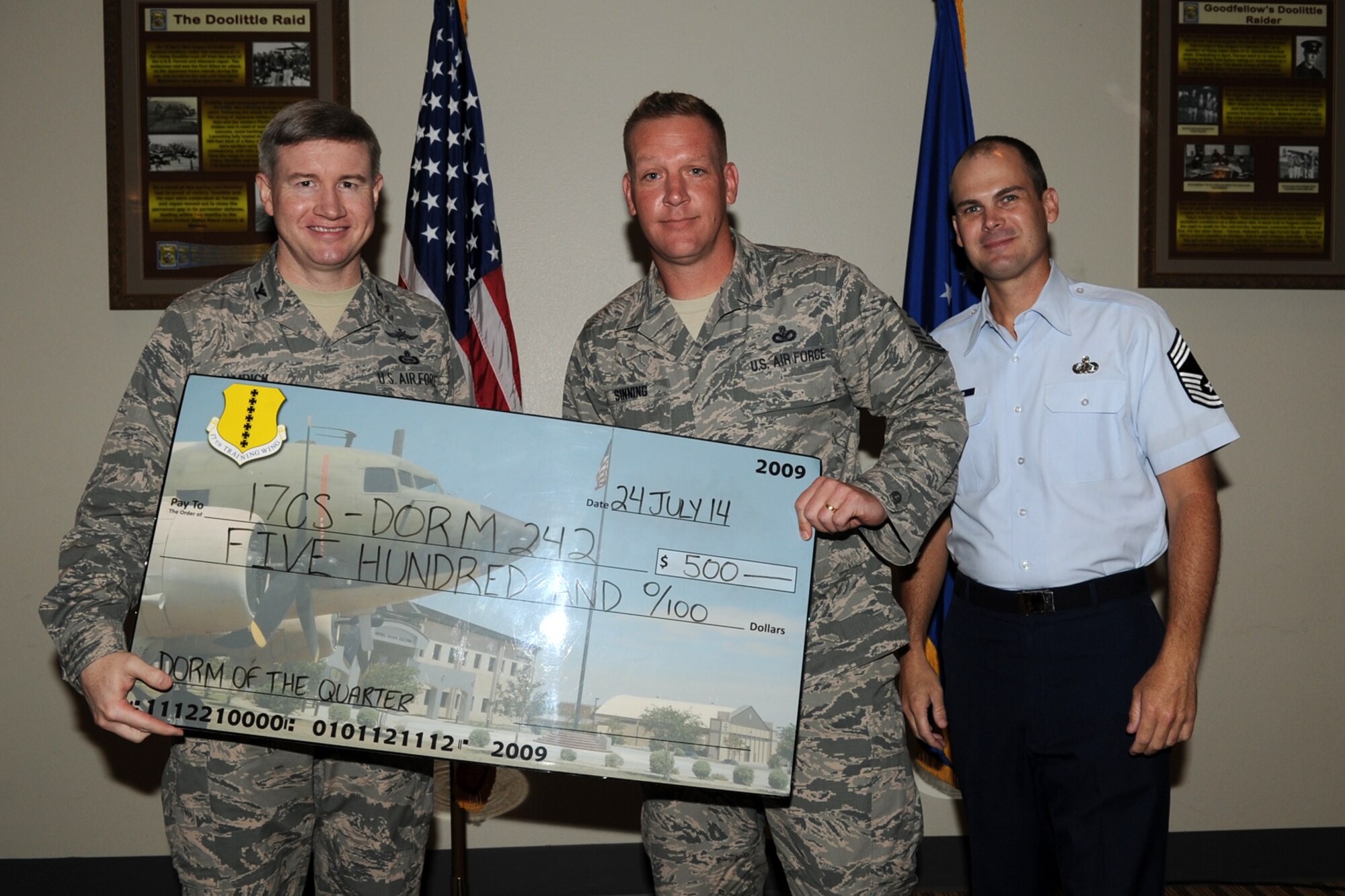 GOODFELLOW AIR FORCE BASE, Texas - Col. Terry J. Hamrick Jr., 17th Training Wing Vice Commander, and Chief Master Sgt. Matthew K. Johnson, 17th Mission Support Group superintendent, present Master Sgt. Nathan I. Sinning, 17th Communications Squadron, with the Goodfellow Air Force Base Permanent Party Dormitory of the Quarter award during the wing quarterly awards ceremony at the Event Center here July 21. (U.S. Air Force photo/ Staff Sgt. Laura R. McFarlane)