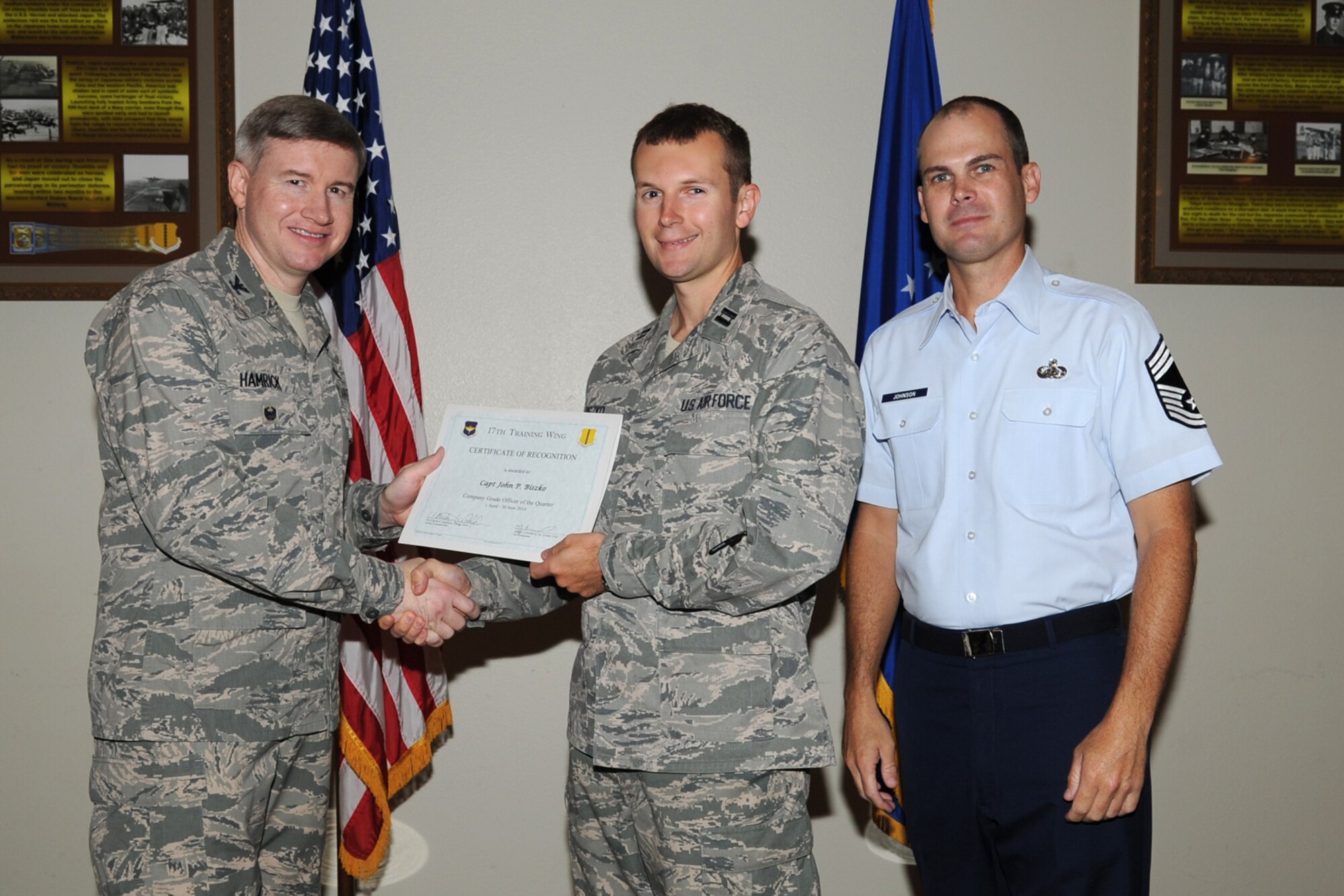 GOODFELLOW AIR FORCE BASE, Texas - Col. Terry J. Hamrick Jr., 17th Training Wing Vice Commander, and Chief Master Sgt. Matthew K. Johnson, 17th Mission Support Group superintendent, present the 17th Training Wing Company Grade Officer of the Quarter Category award to Capt. John P. Biszko, 315th Training Squadron, during the wing quarterly awards ceremony at the Event Center here July 21. (U.S. Air Force photo/ Staff Sgt. Laura R. McFarlane)