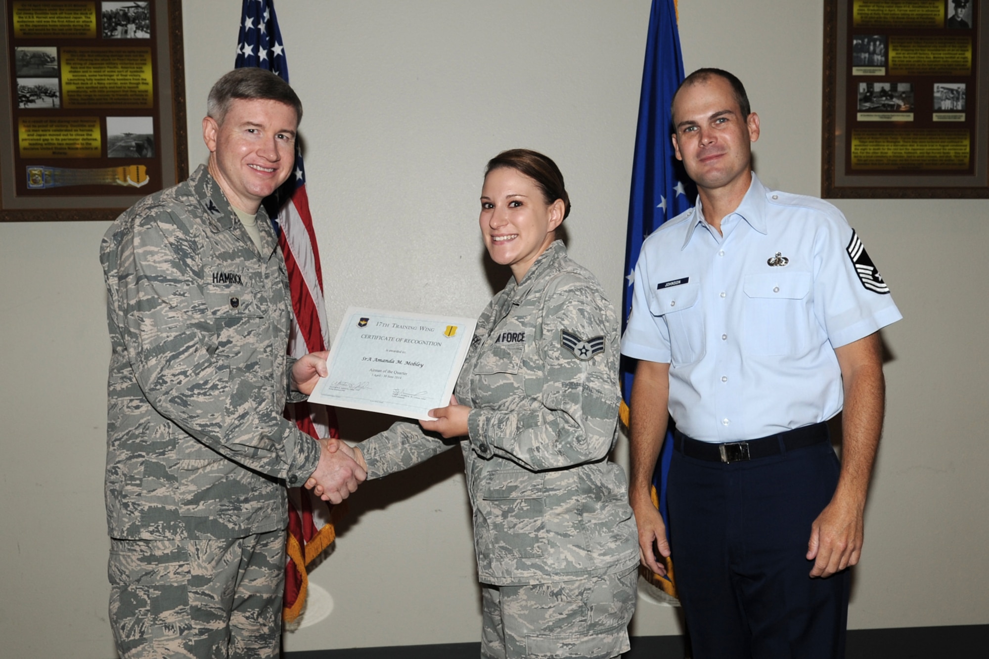 GOODFELLOW AIR FORCE BASE, Texas - Col. Terry J. Hamrick Jr., 17th Training Wing Vice Commander, and Chief Master Sgt. Matthew K. Johnson, 17th Mission Support Group superintendent, present the 17th Training Wing Airman of the Quarter award to Senior Airman Amanda M. Mobley, 17th Medical Operations Squadron, during the wing quarterly awards ceremony at the Event Center here July 21. (U.S. Air Force photo/ Staff Sgt. Laura R. McFarlane)