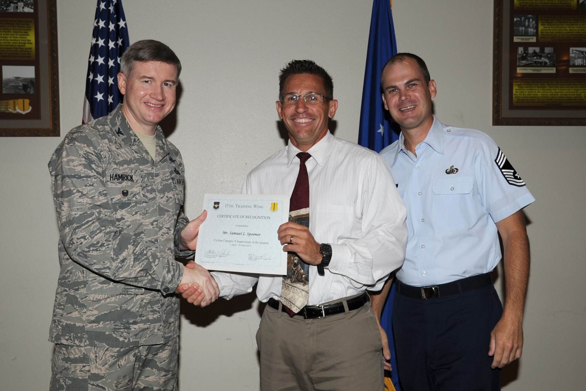 GOODFELLOW AIR FORCE BASE, Texas - Col. Terry J. Hamrick Jr., 17th Training Wing Vice Commander, and Chief Master Sgt. Matthew K. Johnson, 17th Mission Support Group superintendent, present the 17th Training Wing Civilian Category II Supervisory of the Quarter award to Samuel L. Spooner, 17th Training Wing Safety Chief, during the wing quarterly awards ceremony at the Event Center here July 21. (U.S. Air Force photo/ Staff Sgt. Laura R. McFarlane)