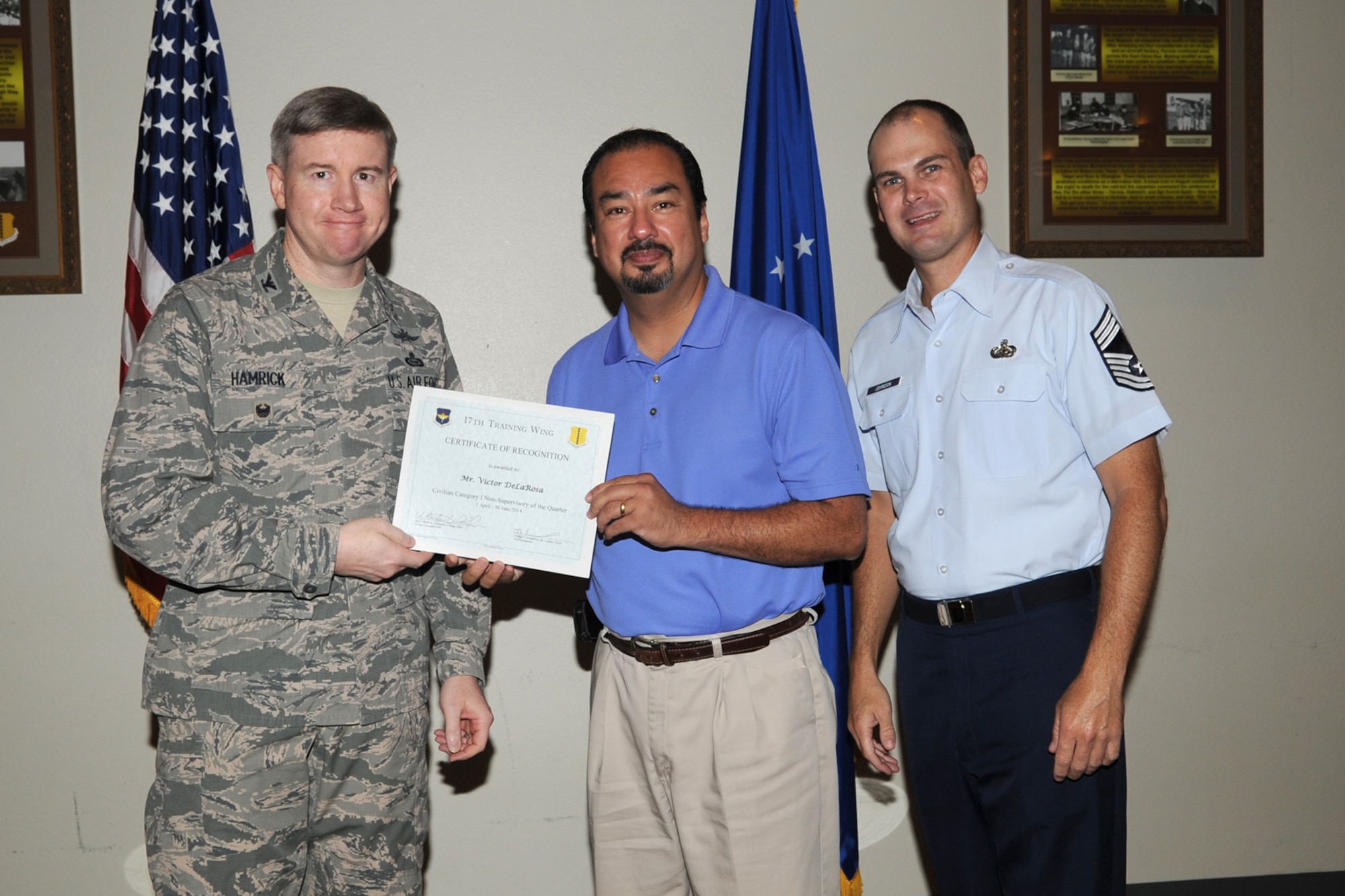 GOODFELLOW AIR FORCE BASE, Texas - Col. Terry J. Hamrick Jr., 17th Training Wing Vice Commander, and Chief Master Sgt. Matthew K. Johnson, 17th Mission Support Group superintendent, present the 17th Training Wing Civilian Category I Non-supervisory of the Quarter award to Victor L. De La Rosa, 17th Civil Engineer Squadron, during the wing quarterly awards ceremony at the Event Center here July 21. (U.S. Air Force photo/Staff Sgt. Laura R. McFarlane)