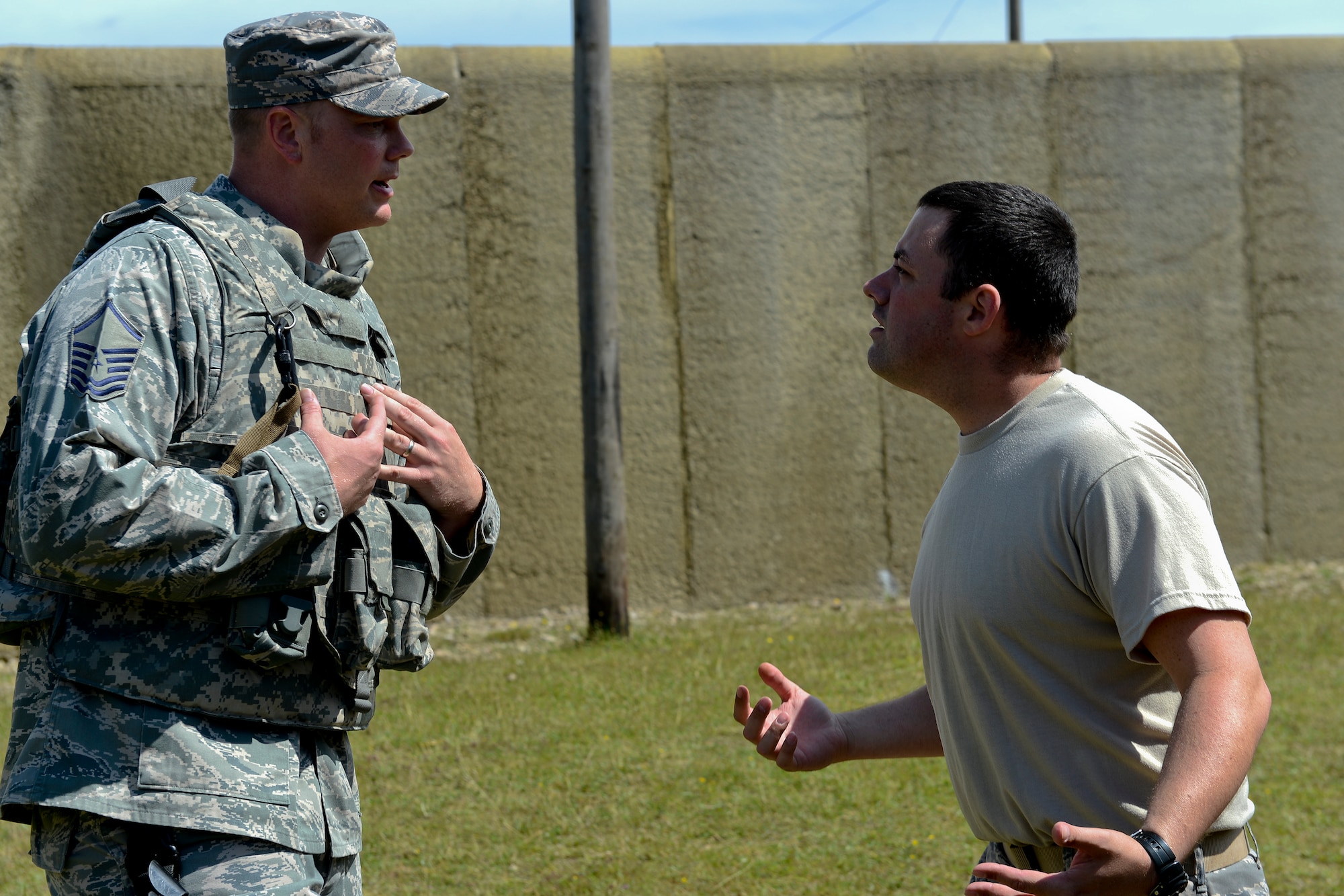 Master Sgt. Matthew Pease (left), 48th Security Forces Squadron plans and programs superintendent, talks with a simulated service member in a domestic call scenario during force-on-force training at the Stanford Training Area in Norfolk, England, July 29, 2014. Defenders from the 48th SFS conducted a day of training at STANTA, an area that offers a realistic environment for Airmen to train. (U.S. Air Force photo by Airman 1st Class Trevor T. McBride)