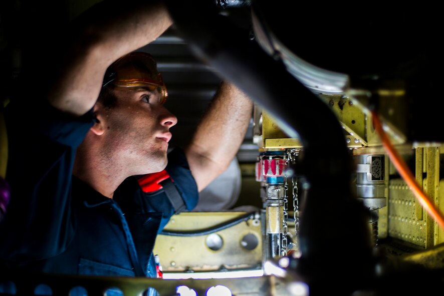 U.S. Air Force Airman 1st Class Daniel Curlew, 75th Aircraft Maintenance Unit crew chief, installs a hydraulic reservoir into an A-10C Thunderbolt II at Moody Air Force Base, Ga., July 30, 2014. The reservoir had to be replaced prior to flight due to a leak. (U.S. Air Force photo by Airman 1st Class Ryan Callaghan/Released)