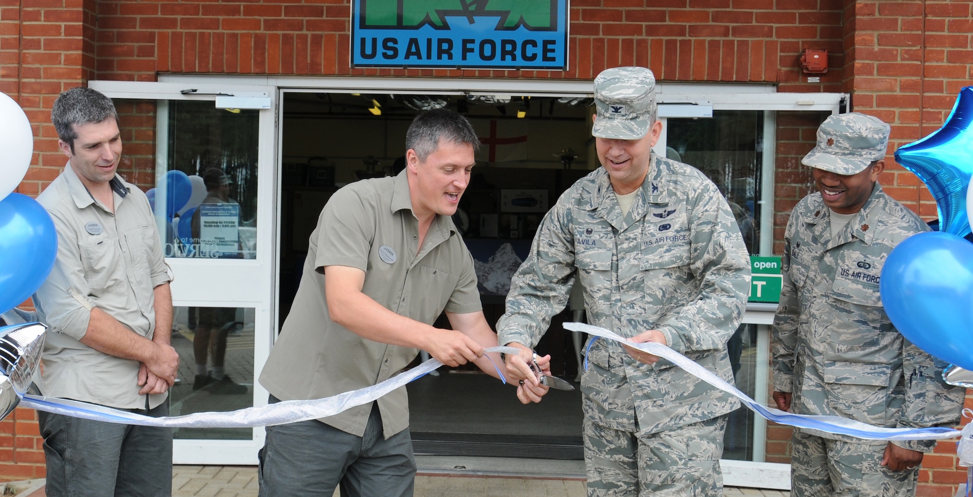 U.S. Air Force Col. David Avila, second from right, 100th Mission Support Group commander, and David Wainwright, second from left, 100th Force Support Squadron Outdoor Recreation Center manager from Telford, England, cut the ribbon at the outdoor recreation center re-opening event July 30, 2014, on RAF Mildenhall, England. Following the official re-opening, guests had the opportunity to look in the new store and talk to staff about the services the center provides. (U.S. Air Force photo/Gina Randall/Released)