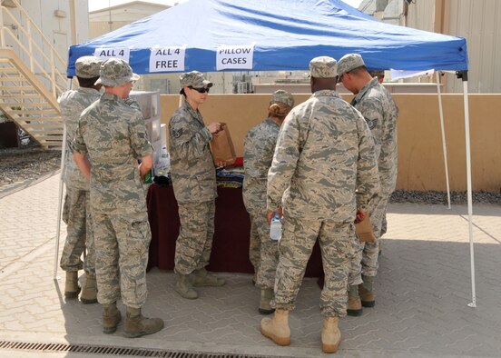 Airmen assigned to the 380th Air Expeditionary Wing at an undisclosed location in Southwest Asia take advantage of an event set up by chapel staff to distribute donated items sent from home July 18, 2014. (U.S. Air Force photo by Senior Master Sgt. Eric Peterson/Released)