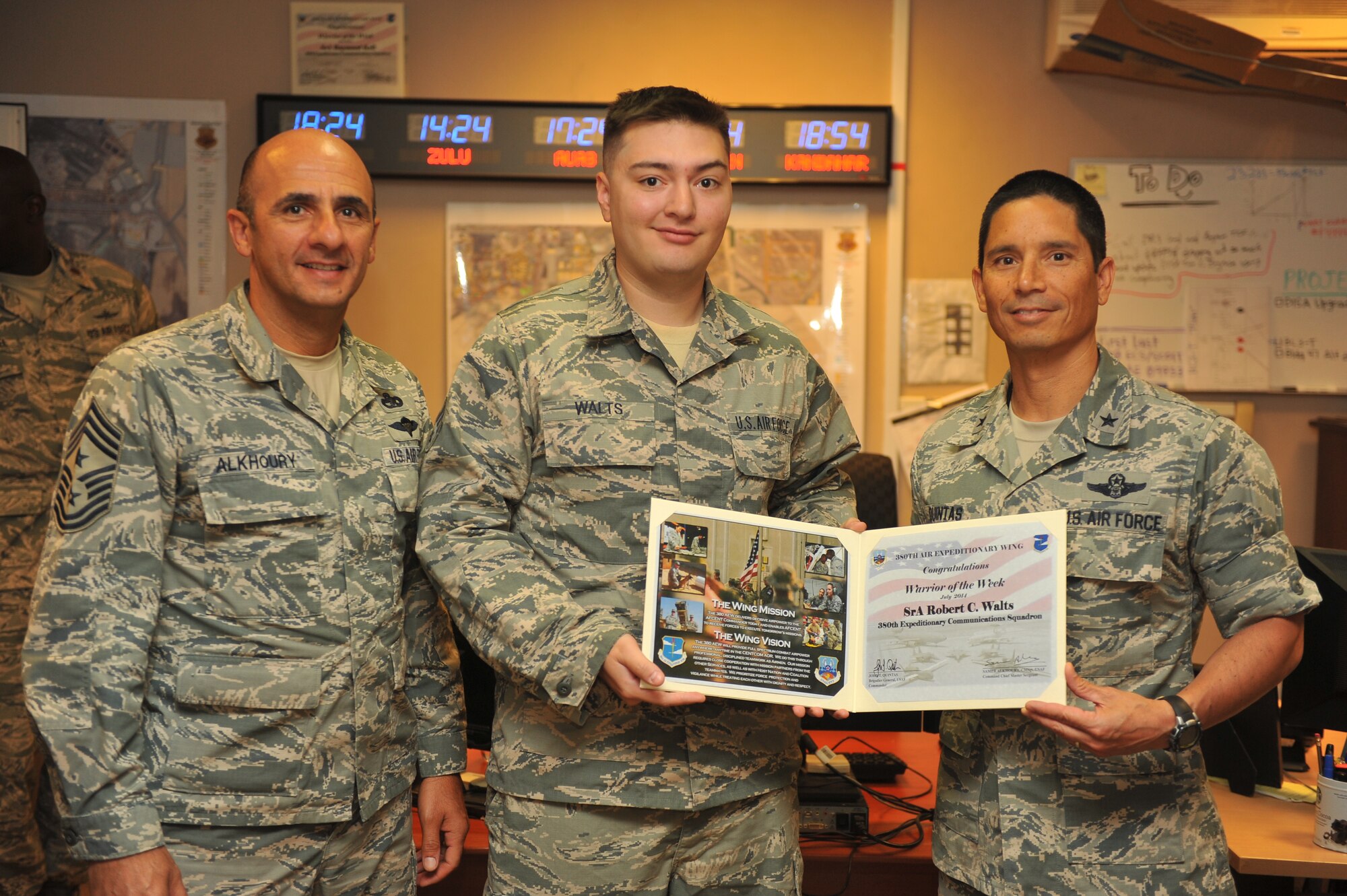 Air Force Brig. Gen. John Quintas, 380th Air Expeditionary Wing commander, and Chief Master Sgt. Samer Alkhoury, 380th Air Expeditionary Wing command chief, present Air Force Senior Airman Robert Walts, 380th Expeditionary Communications Squadron technical control, a warrior of the week certificate at an undisclosed location in Southwest Asia, July 30, 2014. Walts is deployed from Joint Base Langley-Eustis, Va. (U.S. Air Force photo by Tech. Sgt. Russ Scalf/Released)