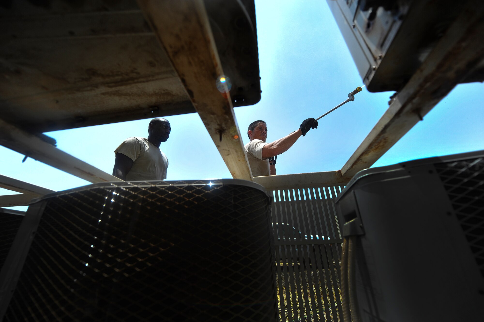 Brig. Gen. John T. Quintas (right), 380th Air Expeditionary Wing commander, and Senior Airman James Jenkins, a 380th Expeditionary Civil Engineer Squadron heating, ventilation, air conditioning and refrigeration journeyman, perform preventative maintenance on an air conditioning unit July 28, 2014, at an undisclosed location in Southwest Asia. The preventative maintenance eliminates many equipment breakdowns before they begin. Quintas spent the day with the chiller team to gain a better understanding of how Airmen contribute to the mission. (U.S. Air Force photo by Tech. Sgt. Russ Scalf/Released)
