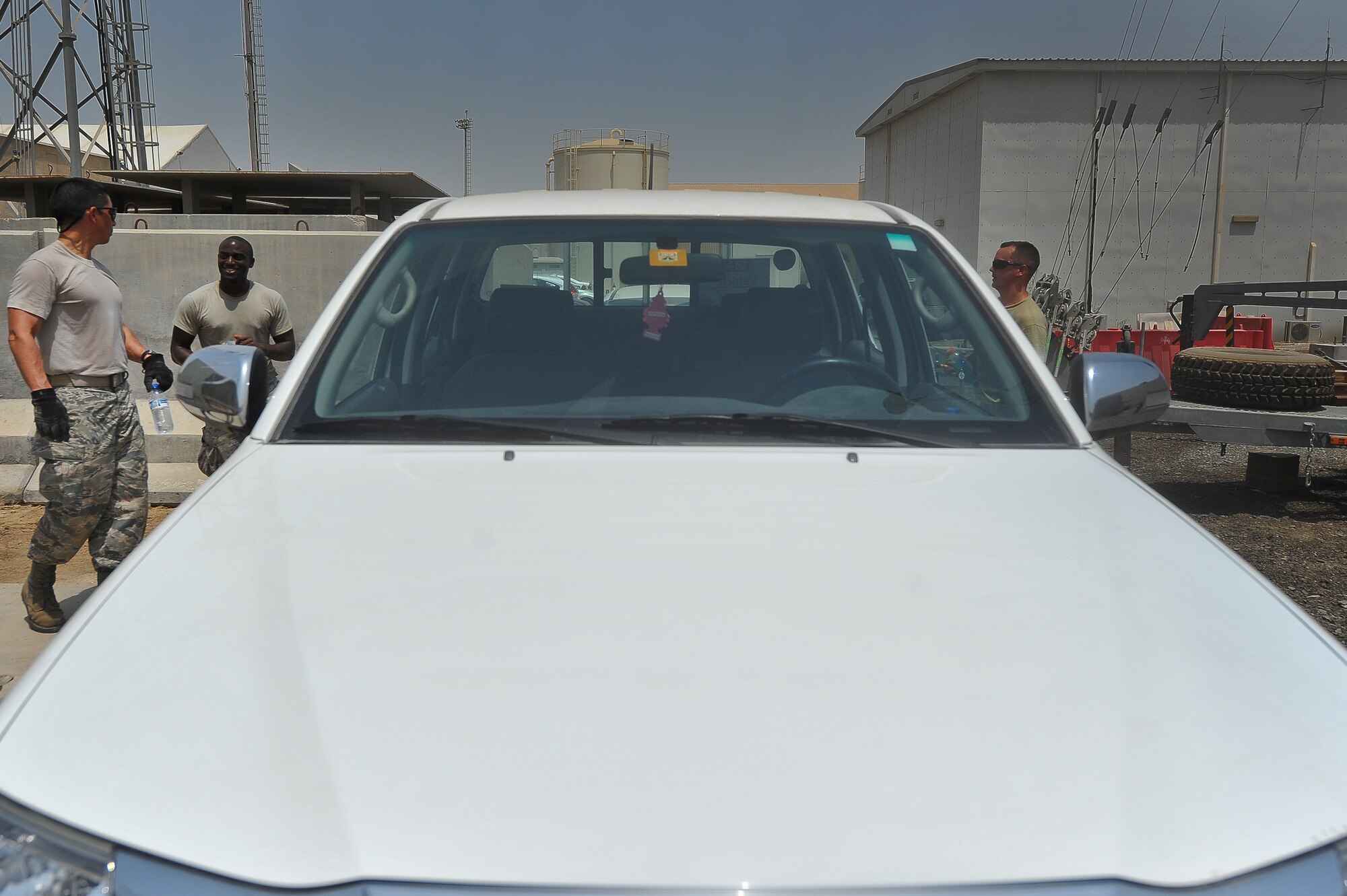 Brig. Gen. John T. Quintas, 380th Air Expeditionary Wing commander, Senior Airman James Jenkins and Staff Sgt. Franklin Sallis, 380th Expeditionary Civil Engineer Squadron, discuss the next job on their schedule July 28, 2014, at an undisclosed location in Southwest Asia. Quintas was spending the day working as a heating ventilation and air conditioning technician to gain a better understanding of how Airmen contribute to the mission. (U.S. Air Force photo by Tech. Sgt. Russ Scalf/Released)