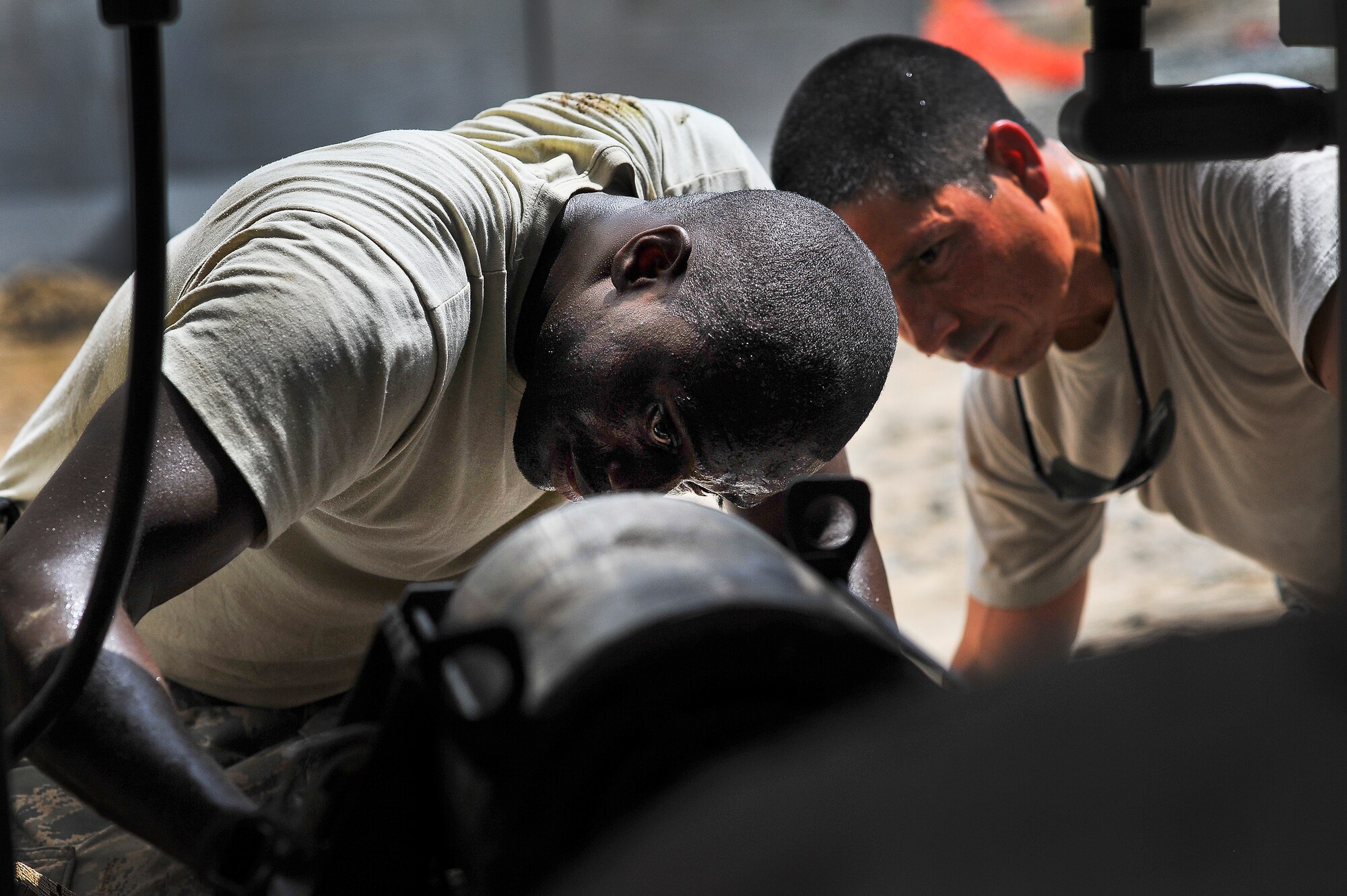 Brig. Gen. John T. Quintas (right), 380th Air Expeditionary Wing commander, and Senior Airman James Jenkins, a 380th Expeditionary Civil Engineer Squadron heating, ventilation and air conditioning journeyman, troubleshoot a chilled water pump July 28, 2014, at an undisclosed location in Southwest Asia. Quintas spent the day assisting a chiller crew with maintenance to gain a better understanding of how Airmen contribute to the mission. (U.S. Air Force photo by Tech. Sgt. Russ Scalf/Released)