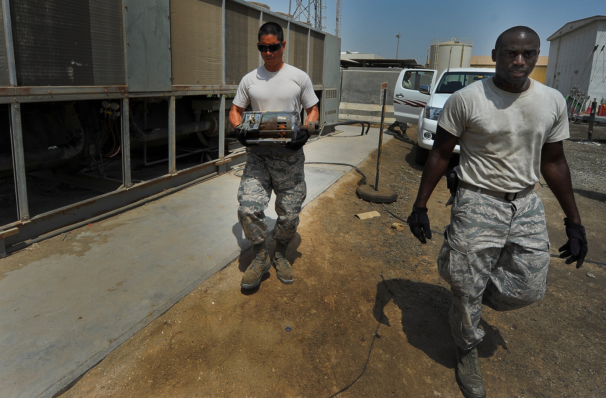 Brig. Gen. John T. Quintas, 380th Air Expeditionary Wing commander, and Senior Airman James Jenkins, a 380th Expeditionary Civil Engineer Squadron heating, ventilation, air conditioning and refrigeration journeyman, arrive at a job site July 28, 2014, at an undisclosed location in Southwest Asia. Quintas was helping to replace a chilled water pump to gain a better understanding of how Airmen contribute to the mission. (U.S. Air Force photo by Tech. Sgt. Russ Scalf/Released)