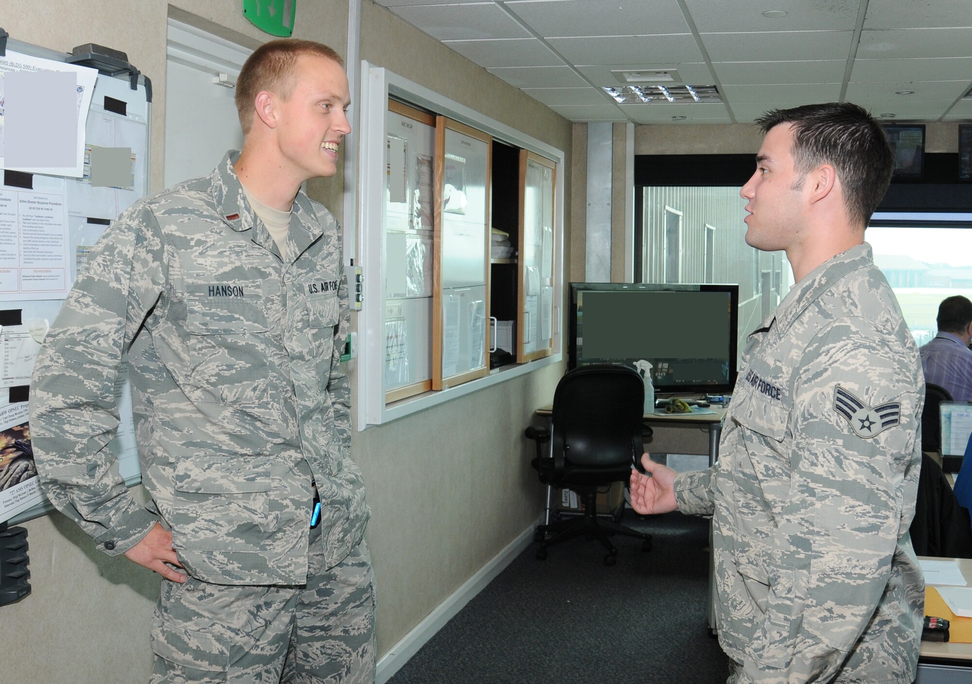 U.S. Air Force 2nd Lt. Evan Hanson, left, 727th Air Mobility Squadron Air Terminal Operations Center duty officer from Hotchkiss, Colo., discusses an assistance upload for the 352nd Special Operations Group with U.S. Air Force Senior Airman Patrick Lerman, 727th AMS ATOC information controller from Boston, July 18, 2014, on RAF Mildenhall, England. Hanson’s team coordinates all outside requests for agency support and information, distributes them to the sections and conveys all this information to Scott Air Force Base, Ill., in order to get the mission completed. (U.S. Air Force photo/Gina Randall/Released)