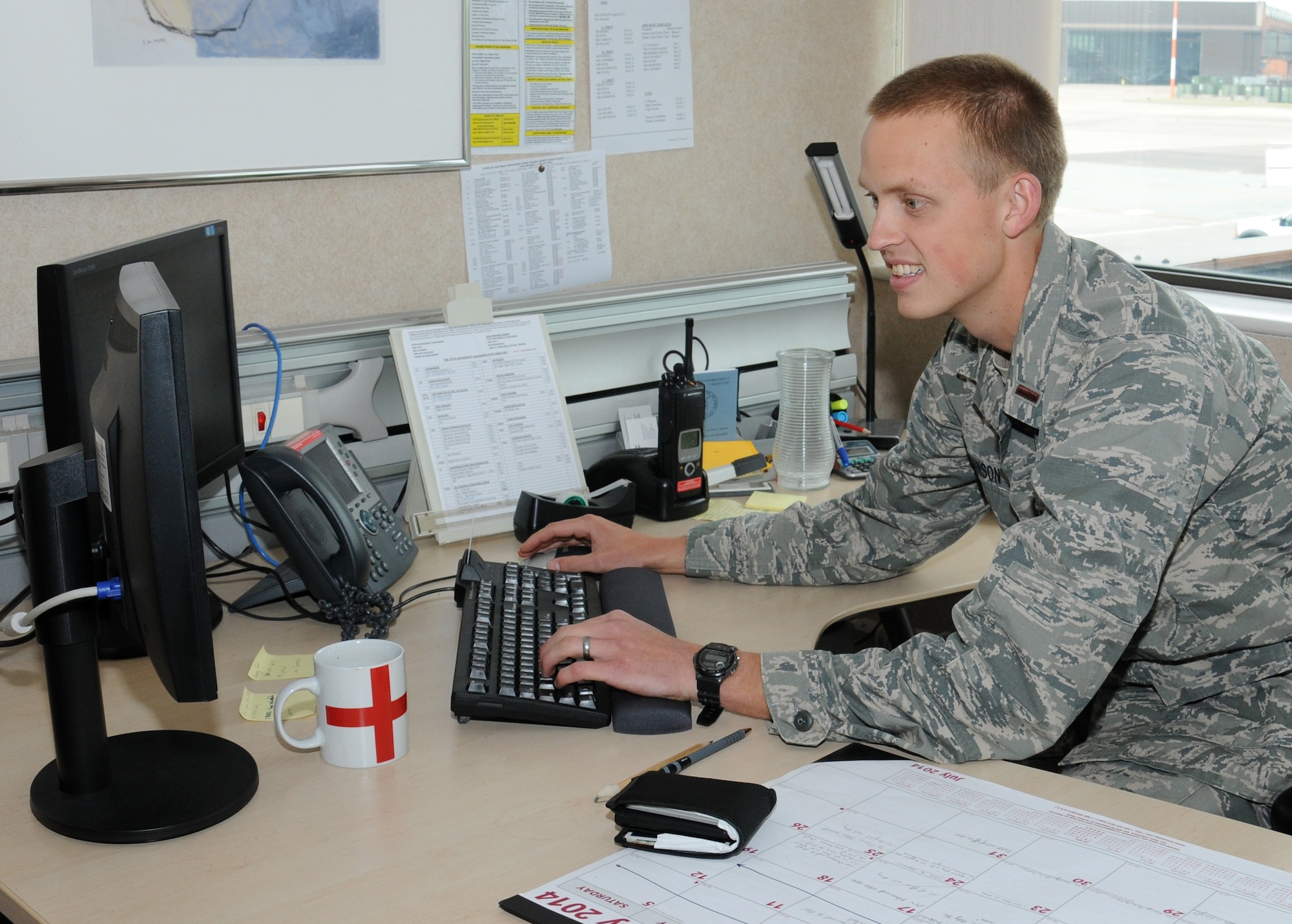 U.S. Air Force 2nd Lt. Evan Hanson, 727th Air Mobility Squadron Air Terminal Operations Center duty officer from Hotchkiss, Colo., checks the daily aircraft schedule July 18, 2014, on RAF Mildenhall, England. Hanson is responsible for coordinating all aspects of the port, aircrew and aircraft support. (U.S. Air Force photo/Gina Randall/Released)