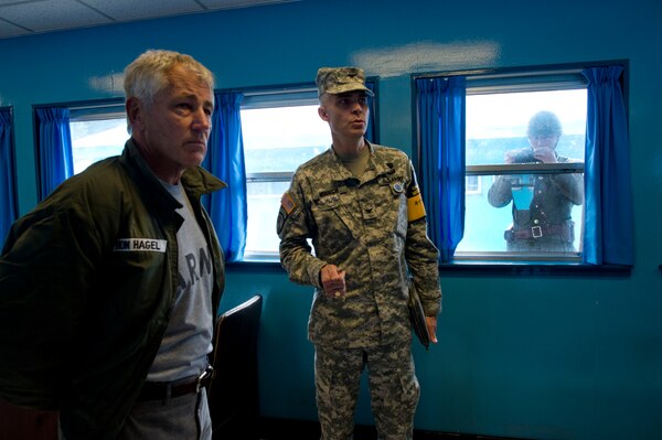 Defense Secretary Chuck Hagel, left, receives a briefing as a North Korean soldier takes pictures of him through a window at Freedom House and Conference Row in Korea’s Demilitarized Zone, Sept. 30, 2013. DOD photo by Erin A. Kirk-Cuomo 