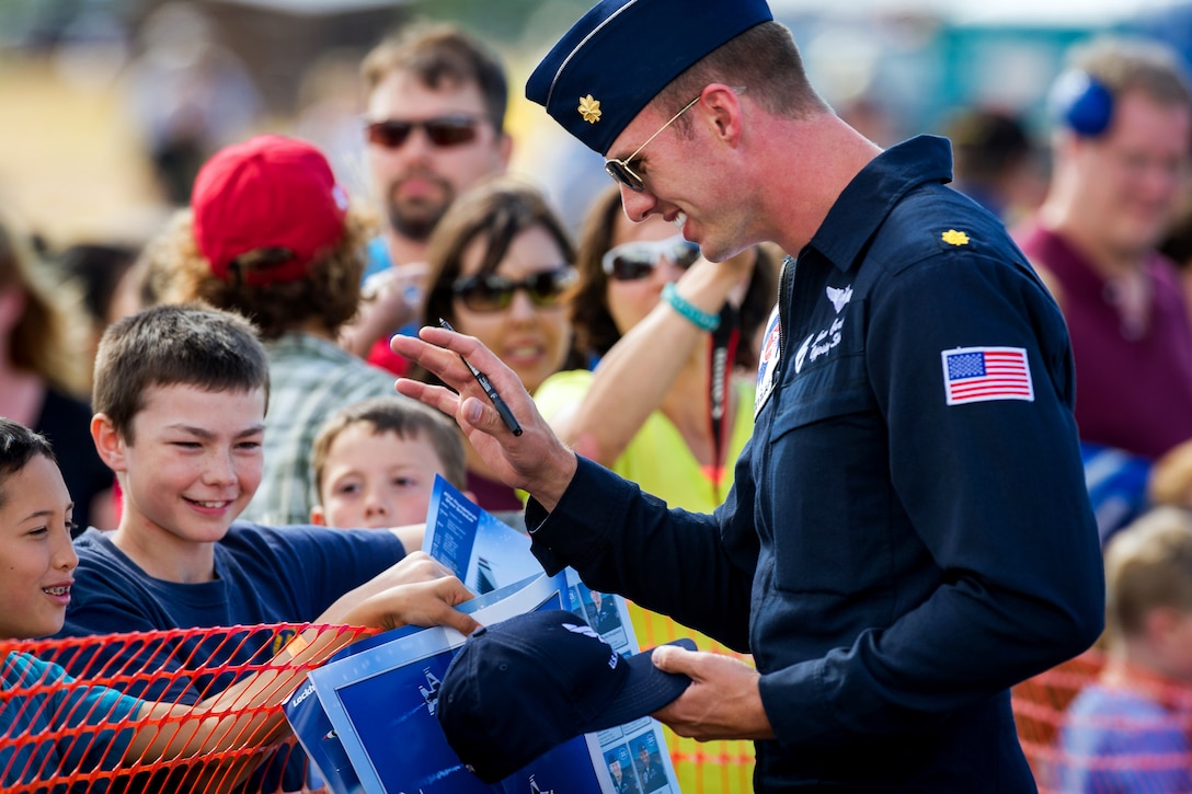 Air Force Maj. Jason Curtis interacts with fans following a performance during the Arctic Thunder Open House on Joint Base Elmendorf-Richardson, Alaska, July 26, 2014. Curtis, a pilot, Thunderbird 6, is assigned to the Thunderbirds Demonstration Team.