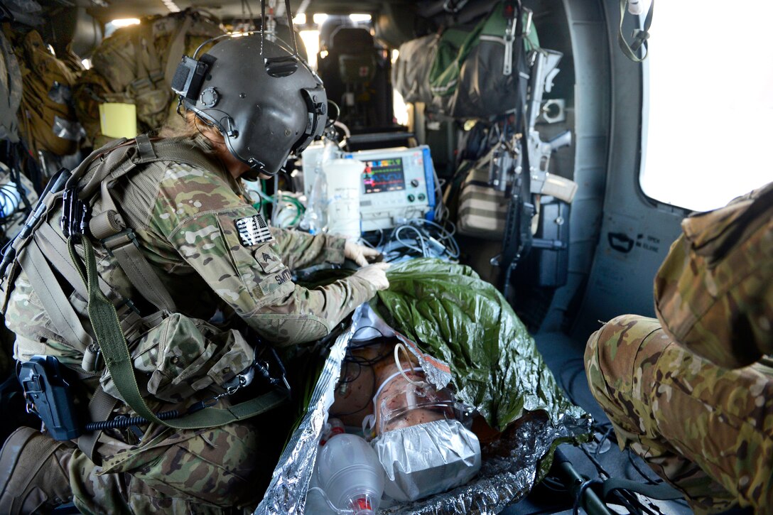 U.S. Army Sgt. Megan Smith prepares a patient for landing during a patient transfer in Afghanistan, July 22, 2014. Smith is a medic assigned to the 159th Combat Aviation Brigade.