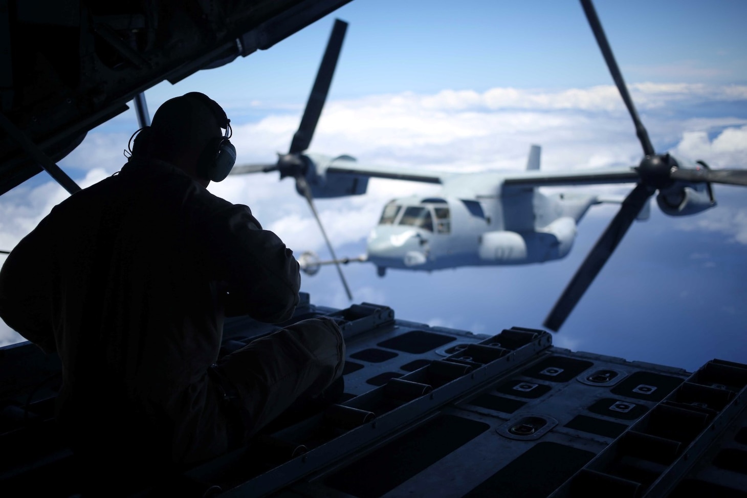 An MV-22B Osprey, with Marine Medium Tiltrotor Squadron 163, 11th Marine Expeditionary Unit, is refueled by a KC-130 en route to Hawaii, July 30th, 2014. Four Ospreys launched from the USS Makin Island and traveled more than 800 nautical miles to insert an element of Marines into a simulated Embassy compound. The MEU departed San Diego on July 25 and is currently deployed as part of WESTPAC 14-2. (U.S. Marine Corps photo by Lance Cpl. Evan R. White/Released)