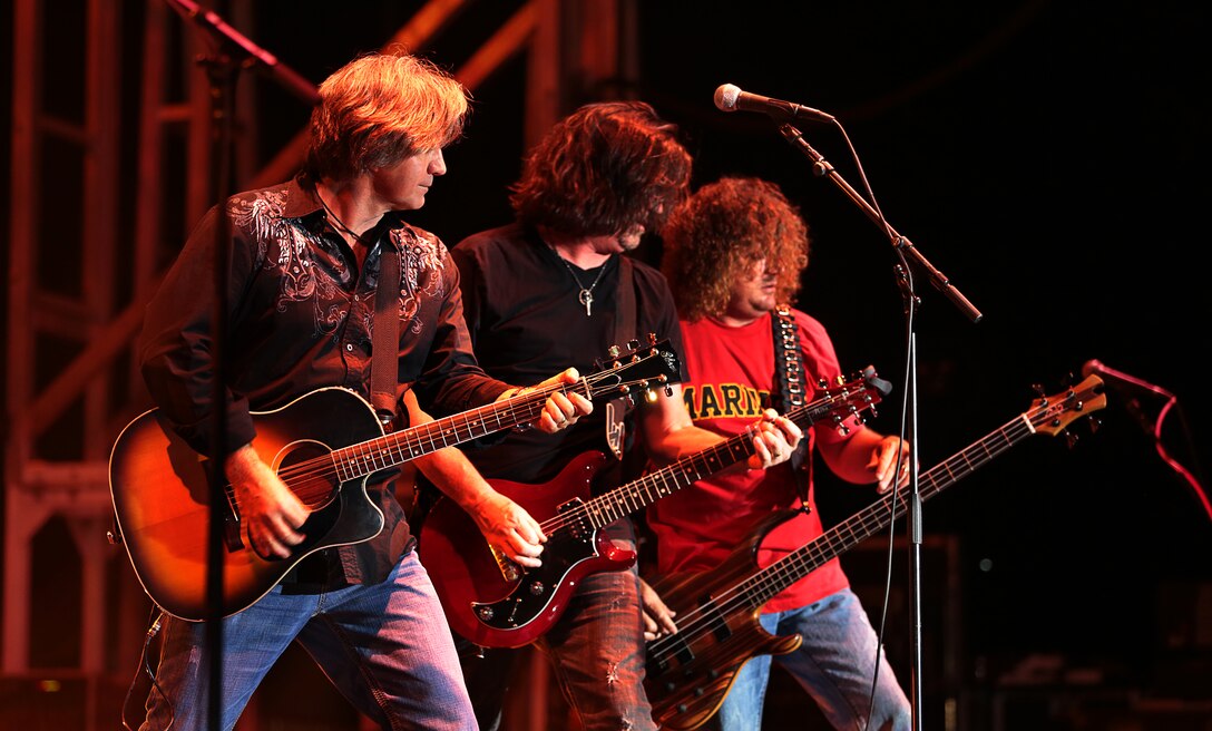 Dwayne O'Brien, rhythm guitarist, Porter Howell, lead vocalist and Duane Propes, bass guitarist, members of Little Texas, an American country band, begins a song by playing closer together during the We Salute You celebration hosted at Lance Corporal Torrey L. Gray Field, May 17, 2014.