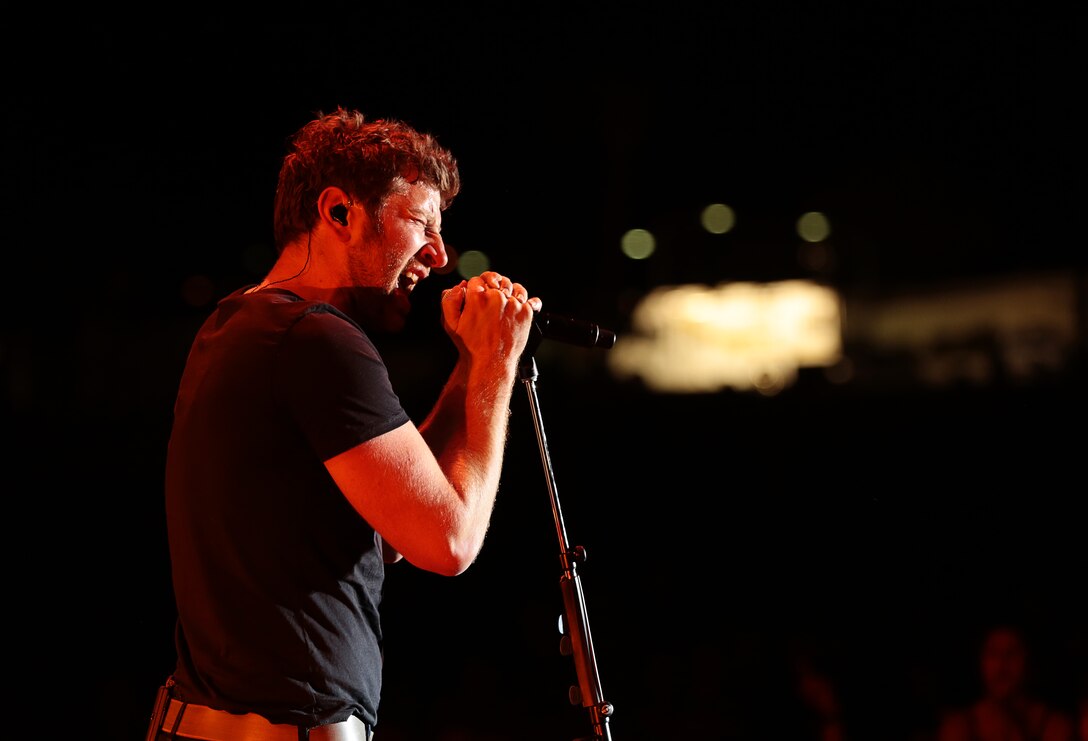 Brett Eldredge, country music star, belts an extended note from one of his songs into the microphone during the We Salute You celebration hosted at Lance Corporal Torrey L. Gray Field, May 17, 2014. Eldredge headlined the event alongside his band and other country artists.