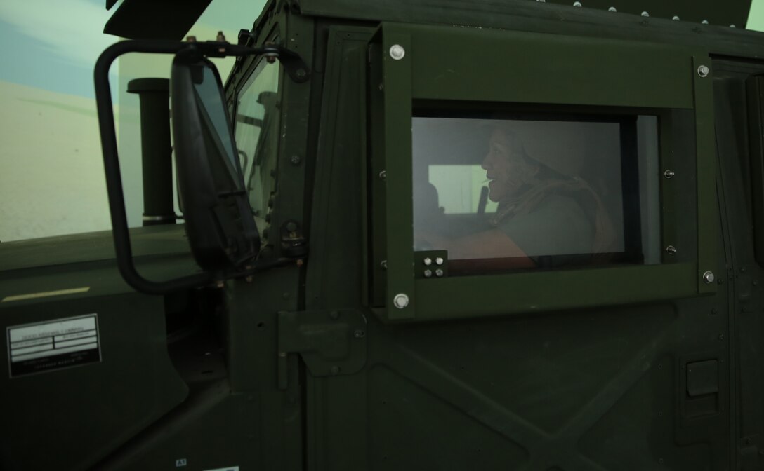 Erika Capistran, family readiness officer, 3rd Combat Engineer Battalion, drives and leads a fire team in the stationary High Mobility Multipurpose Wheeled Vehicle of the Combat Convoy Simulator during the Rosie the Riveter Vs. The Simulator Event hosted at Camp Wilson, May 15, 2014. At every stop of the simulated convoy, spouses dismounted the vehicle to set up security.