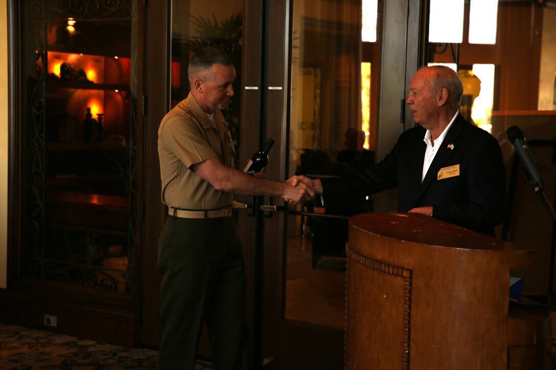 Col. Matthew Jones, commanding officer, Marine Corps Tactics and Operations Group, shakes hands with the George Stettler, president, 1st Marine Division Association, during a luncheon at the Classic Club in Palm Desert, Calif., May 15. The 1st Marine Division Association held a spousal appreciation luncheon at club. The association is made up of members of 1st Marine Division, past and present. They invited the spouses of 1st Marine Division Marines to thank them for their unyielding support and strength of character through their many years as part of the family. Each spouse was acknowledged by name and asked to stand as they were individually recognized and applauded.