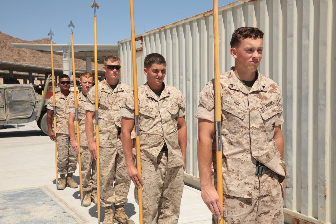 Marines practice commands and execution of guidon movements as a squad during a guidon manual class at the 1st Tank Battalion classroom lot, May 20, 2014. The Marines took turns lining up and critiquing each other to improve their guidon movements.