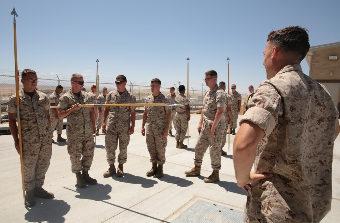 Sgt. Troy Boyd, heavy equipment operator, Marine Wing Air Support Squadron 374, instructs students on the intensity and speed needed to properly present the guidon from the carry position during a guidon manual class at the 1st Tank Battalion classroom lot, May 20, 2014. Marines also went head-to-head in competitions to see which Marine was better with each movement.