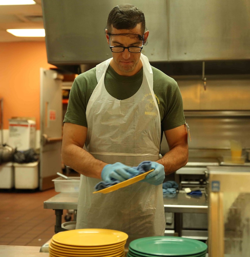 Navy Lt. Travis Jewell, chaplain, 3rd Battalion, 4th Marines, 7th Marine Regiment, cleans dishes during a volunteer event at the St. Vincent de Paul Village, May 25, 2014. The shelter houses approximately 700 citizens in the San Diego area.