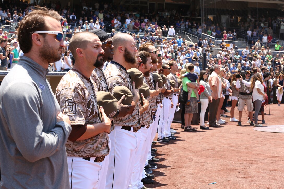 Baseball players with the San Diego Padres observe the national anthem during a San Diego Padres baseball game at Petco Park, May 25, 2014. Service members invited to the game watched the Padres play against the Chicago Cubs.