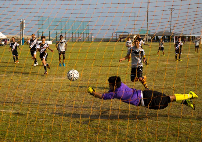 Ryuji Vandeusen, 17, goalie for U.S. Army Garrison Camp Zama, Japan, high school soccer team, dives for a ball during the Department of Defense Education Activities Far East Division Two Boys championship soccer game aboard Marine Corps Air Station Iwakuni, Japan, May 22, 2013. Justin Hill, 17, team captain for Perry, scored the goal with a header off of a blocked penalty kick.