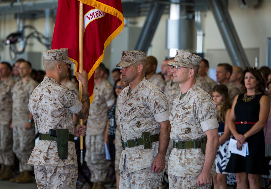 Lt. Col. Bruce D. Gordon, left, prepares to receive the unit colors to pass to Lt. Col. Shawn M. Basco during the Marine All-Weather Fighter Attack Squadron 242 change of command aboard Marine Corps Air Station Iwakuni, Japan, May 23, 2014. Passing of the Colors signifies the passing of command from one commanding officer to another.