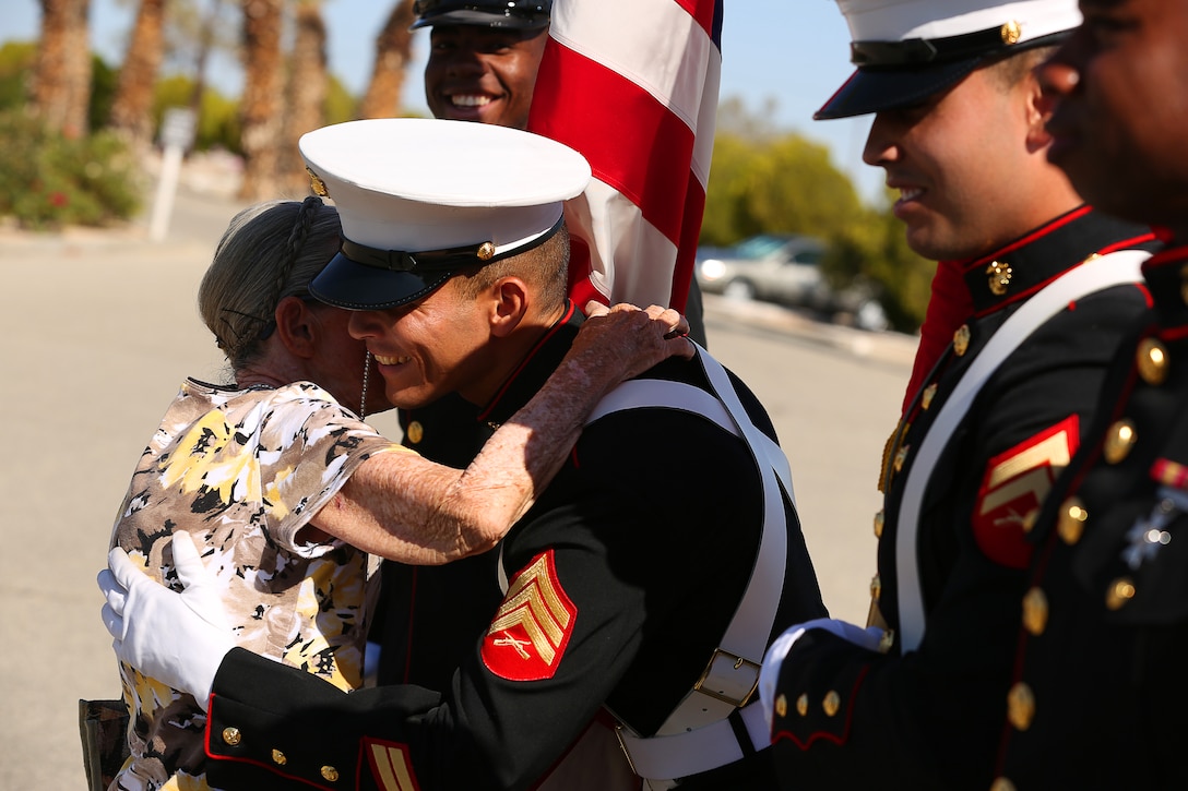 Trudy Knight, the wife of deceased Gunnery Sgt. Charles Knight, hugs Sgt. David Leon of the color guard during the Memorial Day Remembrance at Twentynine Palms Memorial Cemetery, May 26, 2014. With Leon are Lance Cpl. Simon Kellogg, Cpl. Matthew Espinosa and Lance Cpl. Brandon Taylor, who also received hugs from Knight.