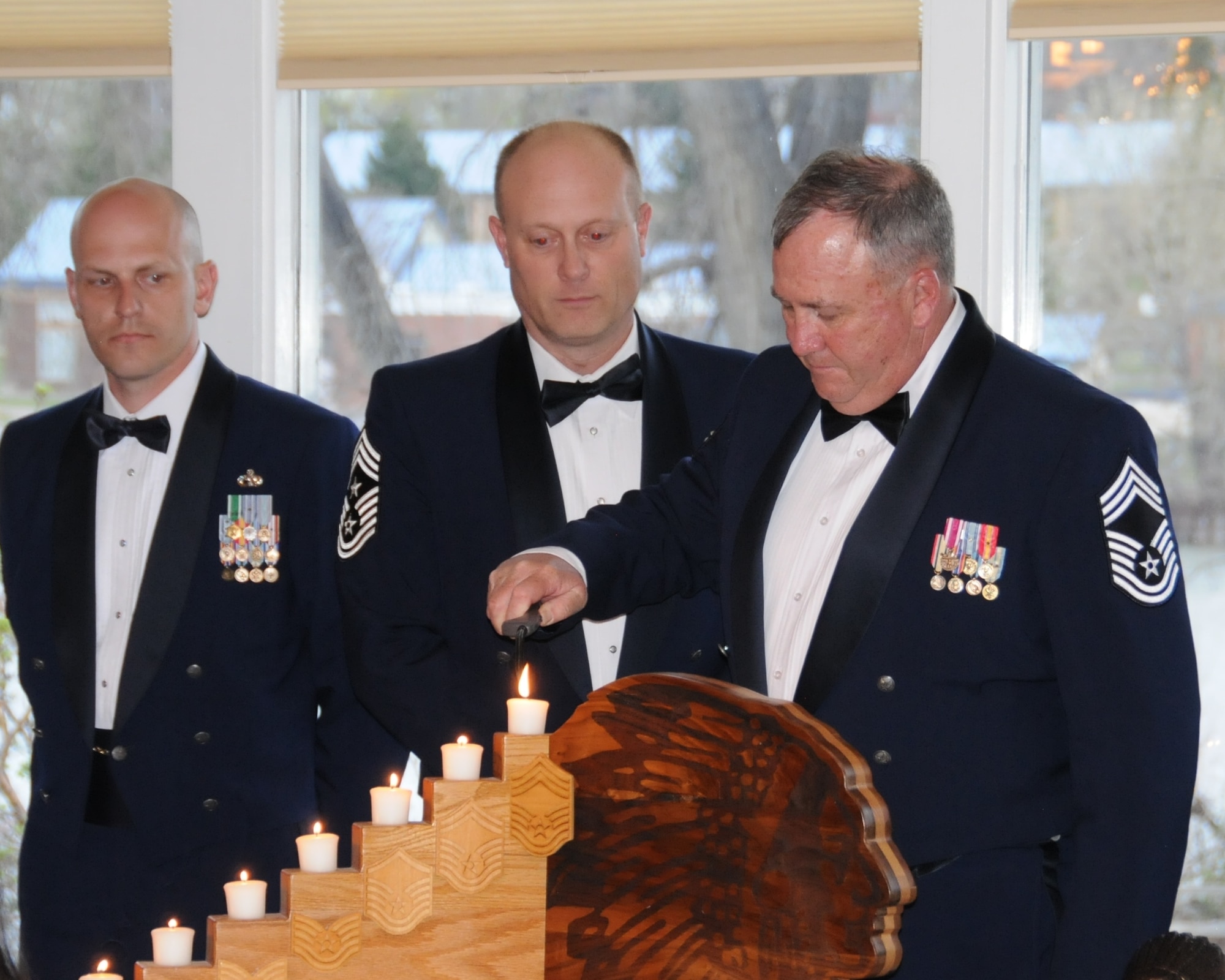 Chief Master Sgt. Randy Remsen, 120th Airlift Wing, lights the candle representing the Chief Master Sgt. rank during the chief’s induction ceremony May 2 at the Meadow Lark Country Club in Great Falls, Montana. (National Guard photo/Staff Sgt. Michael Touchette)