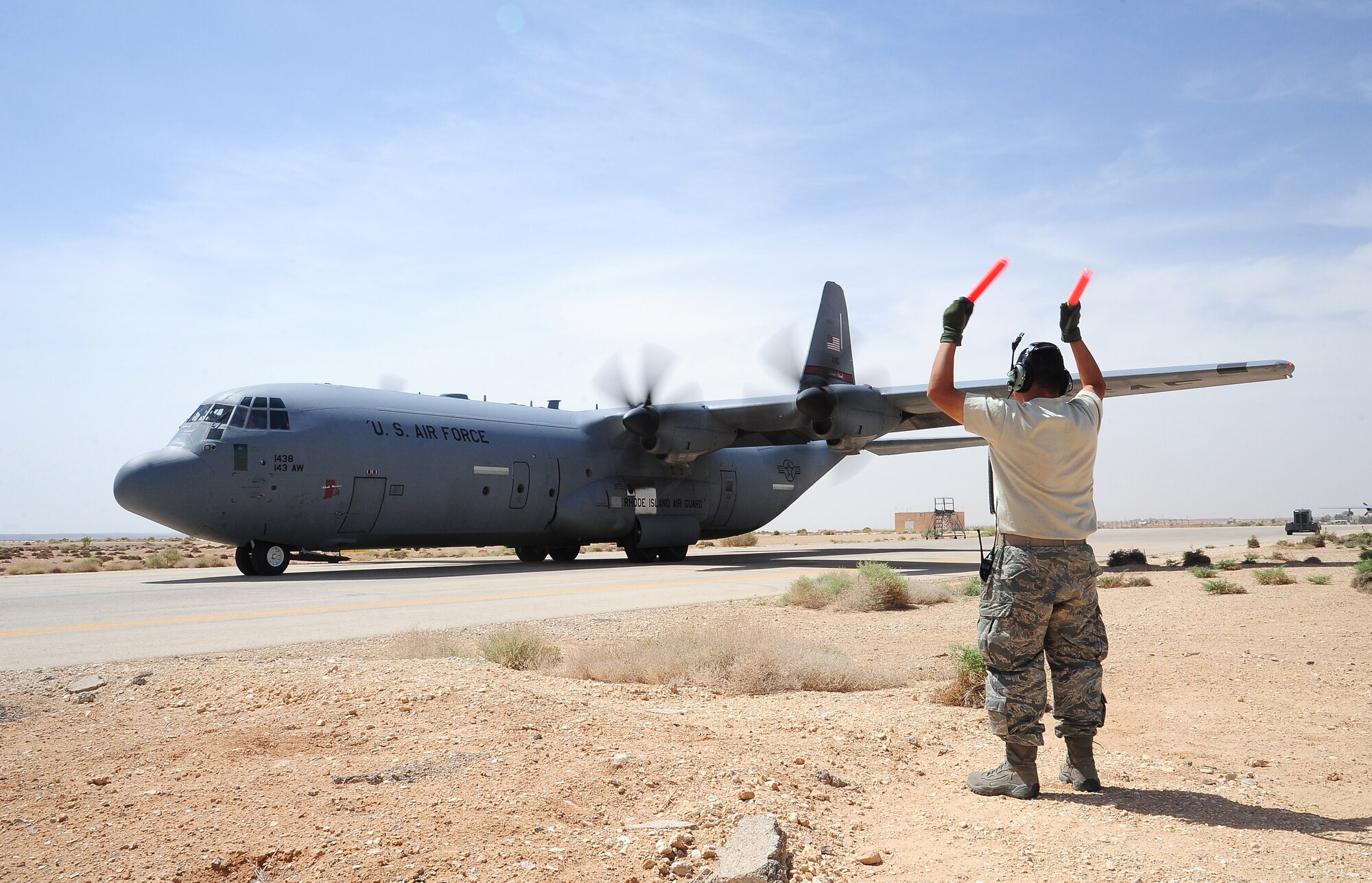 U.S. Air Force Staff Sgt. Willeams Roldan, a crew chief with the 146th Aircraft Maintenance Squadron at Channel Islands Air National Guard Station, Calif., marshals a C-130J Hercules for takeoff during Exercise Eager Lion May 29, 2014, at an air base in northern Jordan. Working alongside partner nation forces gave the U.S. military a chance to enhance their readiness and practice crisis management. (U.S. Air Force photo by Staff Sgt. Brigitte N. Brantley/Released)