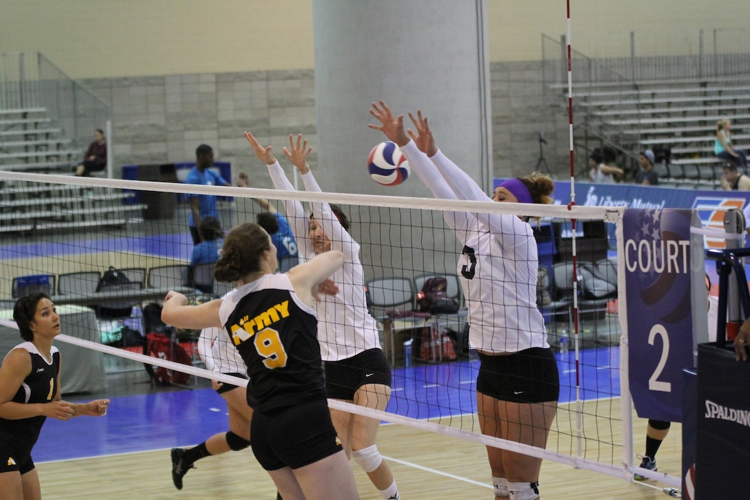 Army CPT Jamie Pecha-#9 (Ft. Bragg, NC) spikes between defenders during the 2014 USA Volleyball National Championships