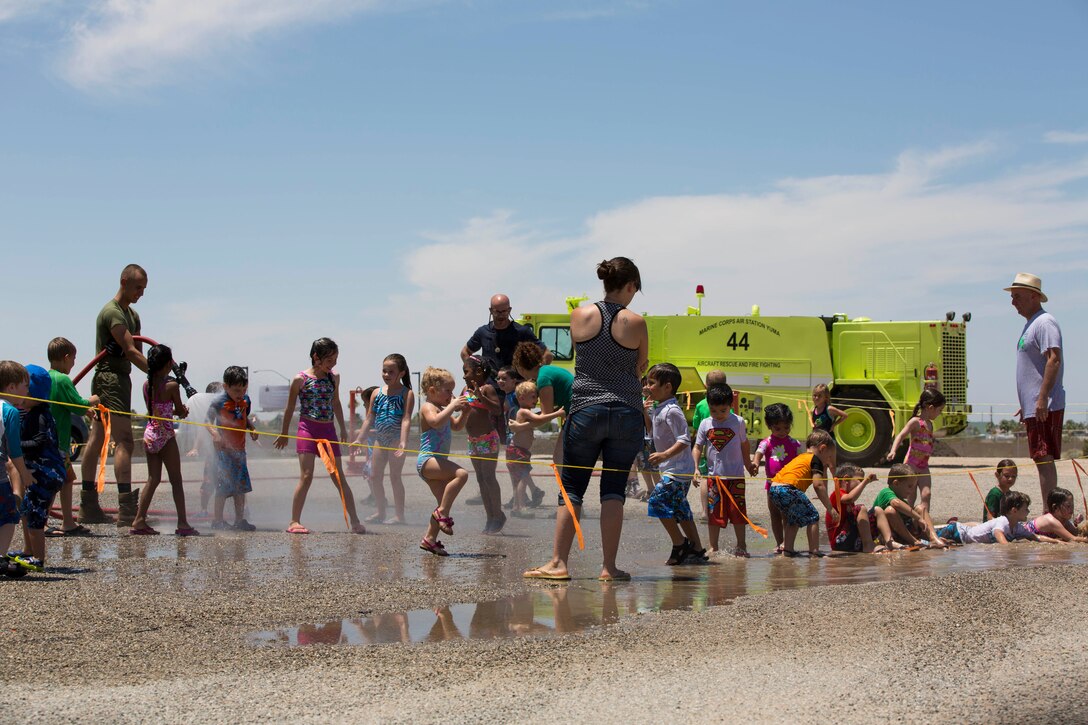 Pvt. Bryan Treff, a Turretman with Aircraft Rescue and Firefighting, stationed at Marine Corps Air Station Yuma, Ariz., and a native of Brentwood, Calif., demonstrates to students, staff and parents the water capabilities of the 1986 Oshkosh P-19A vehicle at the Learning Pad Christian Preschool and Kindergarten school on May 30, 2014. "The kids are truly enjoying this event, and we appreciate the military greatly," said Rose Lerma, preschool teacher at the Learning Pad Christian Preschool and Kindergarten school. "It's great, and it's something we like to see and would hope can be a yearly event."