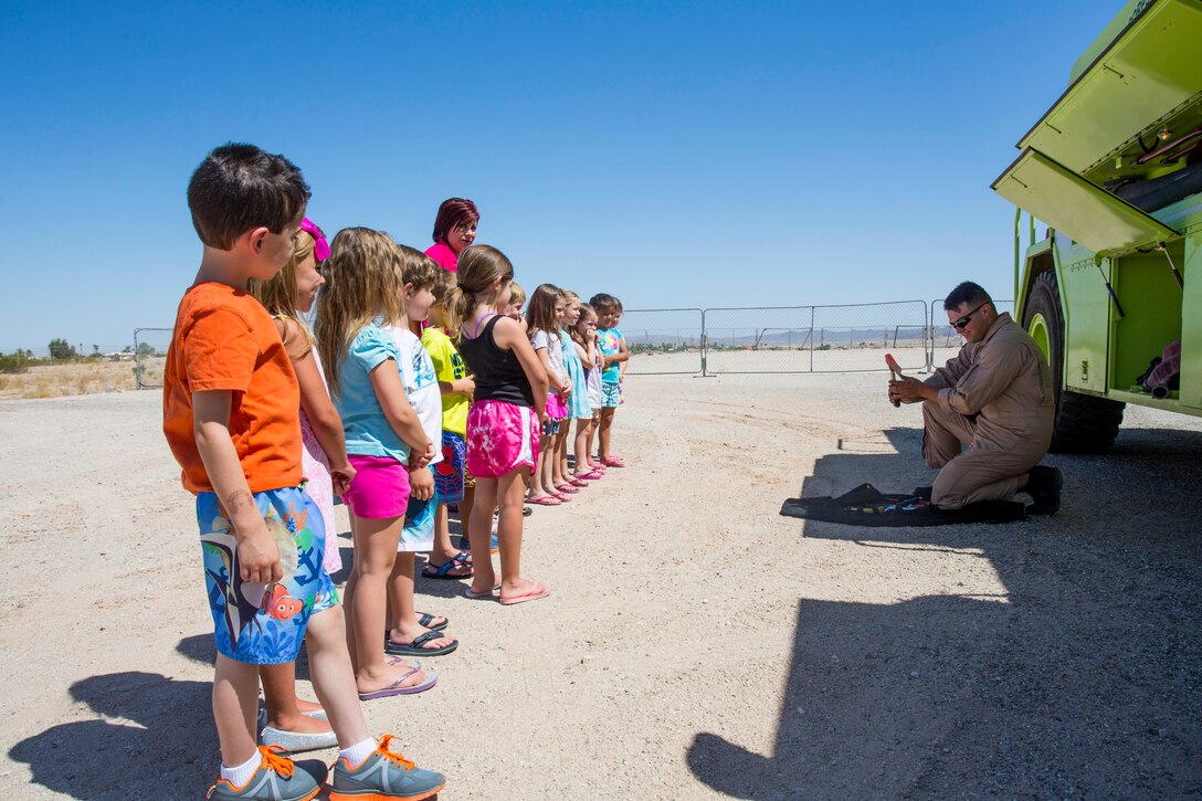 Cpl. Joshua Griffin, a crew chief and operator with Aircraft Rescue and Firefighting, stationed at Marine Corps Air Station Yuma, Ariz., and a native of Lufkin, Texas, demonstrates the various tools used by ARFF Marines to Rose Lerma's preschool students at the Learning Pad Christian Preschool and Kindergarten school on May 30, 2014.