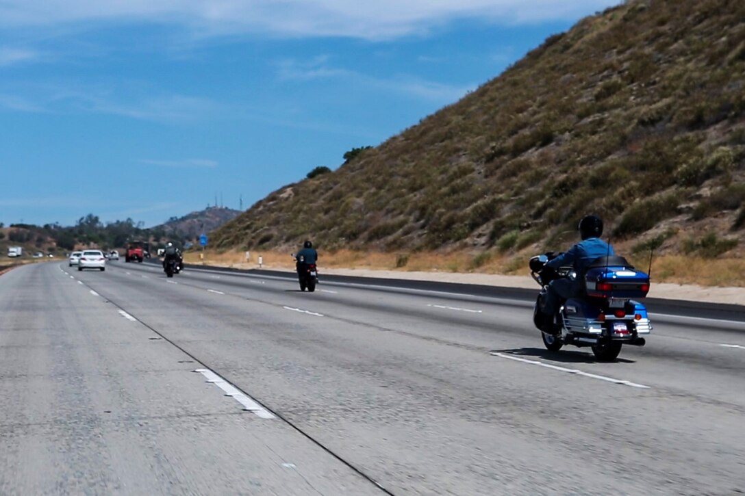 Lieutenant Gen. John A. Toolan, right, commanding general, I Marine Expeditionary Force, rides his motorcycle along Interstate 15 toward Murrieta Calif., May 29, 2014. Nearly 20 Marines participated in the company-sponsored motorcycle ride in an effort to build camaraderie and promote safe motorcycle riding techniques.