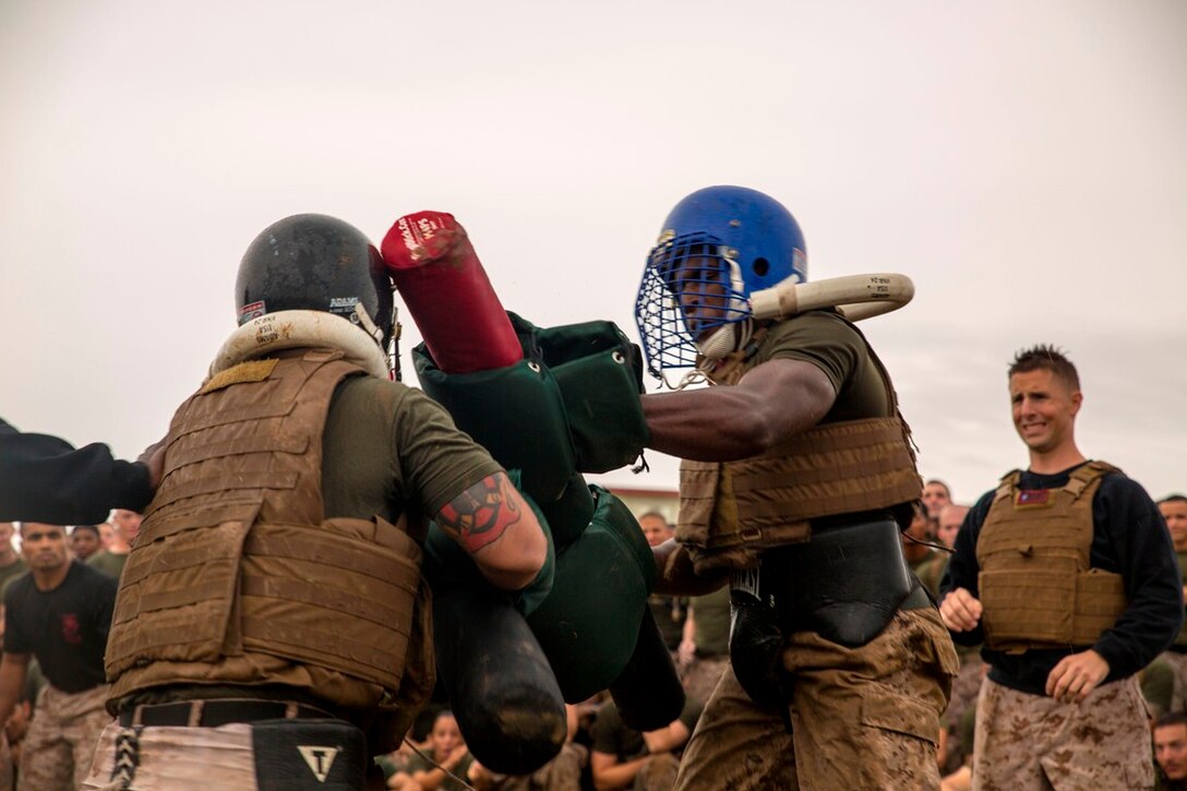 Lance Cpl. Khalil D. Blackwell, right, delivers a scoring blow to his opponent May 23 at Camp Kinser during a pugil stick bout. The event was part of a field meet organized to celebrate 3rd Marine Logistics Group’s 56th anniversary. Despite the rainy weather and muddy field, the day’s events included a pancake breakfast, 5-kilometer run, two multi-unit physical training sessions followed by unit competitions. The competitions pitted the most physically fit Marines within the respective battalions and regiments of 3rd MLG against each other in events such as pugil stick bouts, tug-of-war, Humvee pull, tire flip and a functional fitness relay. This year’s winning unit was Combat Logistics Regiment 3, 3rd MLG, III Marine Expeditionary Force. Blackwell is a combat engineer with Combat Logistics Battalion 4, 3rd MLG, III MEF.