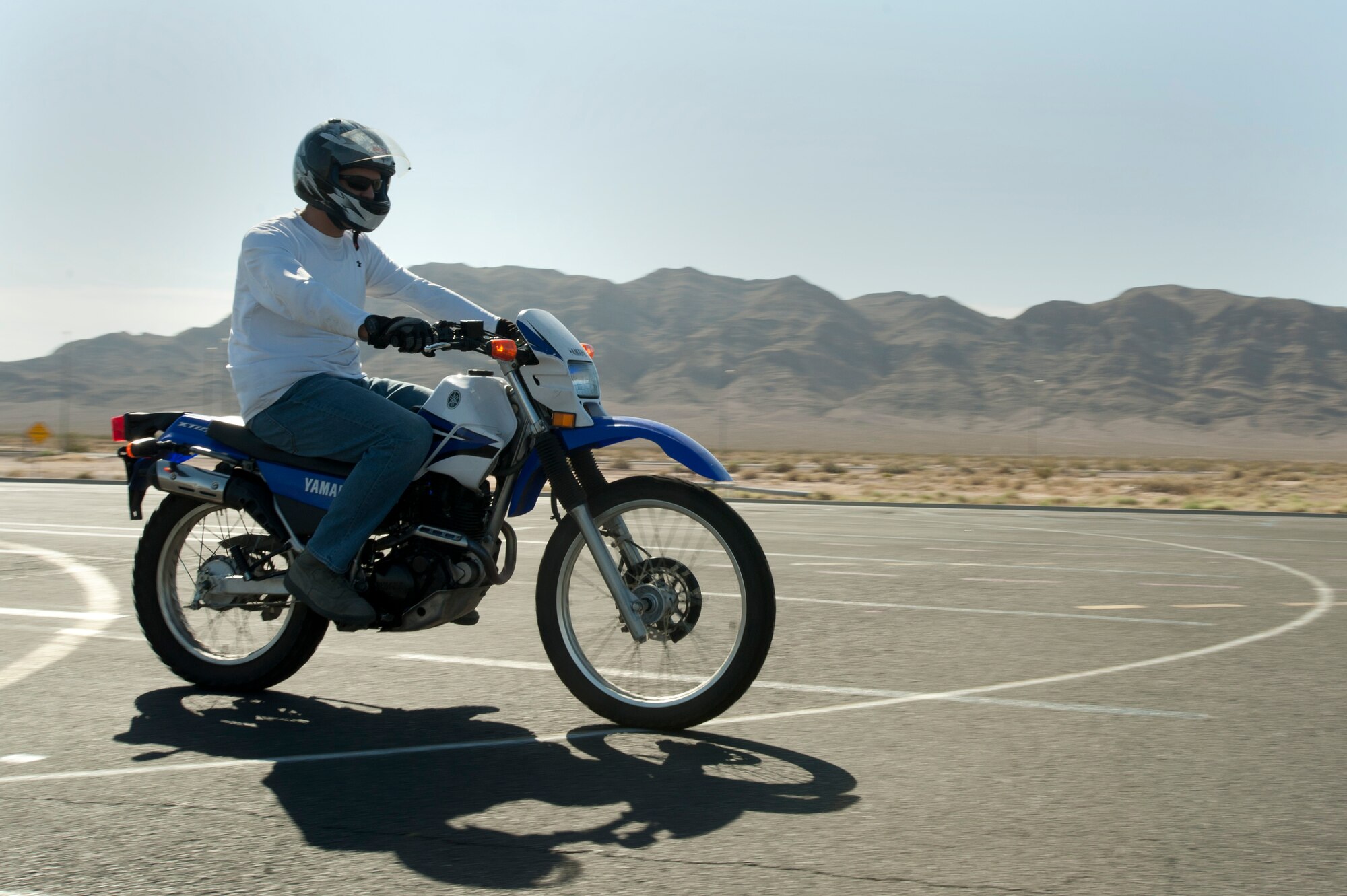 U.S. Air Force Staff Sgt. Raul Olivry, 99th Comptroller Squadron NCO in charge of customer service, rides along a designated path during a basic rider’s course May 29, 2014 at Nellis Air Force Base, Nev. Participation in the 99th ABW Safety office’s initial motorcycle safety course is a mandatory requirement motorcyclists must successfully complete before they can legally ride on or off the installation. (U.S. Air Force photo by Senior Airman Timothy Young)
