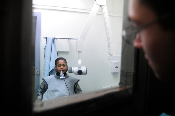 Master Sgt. Nicole Randall, 8th Logistics Readiness Squadron maintenance support chief, receives a dental clearance exam administered by Senior Airman David Tierney, 8th Medical Operations Squadron dental technician, at Kunsan Air Base, Republic of Korea, May 28, 2014. The 8th Medical Group continues to focus on comfort for both the patients and providers as they prepare for upcoming manning gaps. (U.S. Air Force photo by Senior Airman Taylor Curry/Released) 