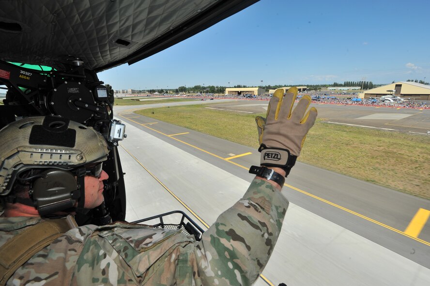 Capt. Marcus Truman, 66th Training Squadron assistant director of operations, waves at the crowd from a UH-1N Iroquois above SkyFest 2014 at Fairchild Air Force Base, Wash., June 1, 2014. The model of light-lift utility helicopter provides both airlift and search and rescue services. SkyFest is Fairchild’s air show and open house, giving the local and regional community the opportunity to view Airmen and our resources. The event typically draws more than 150,000 people. SkyFest 2008, headlined by the Blue Angels, was the largest event held in Spokane since the 1974 World’s Fair. (U.S. Air Force photo by Staff Sgt. Veronica Montes/Released)