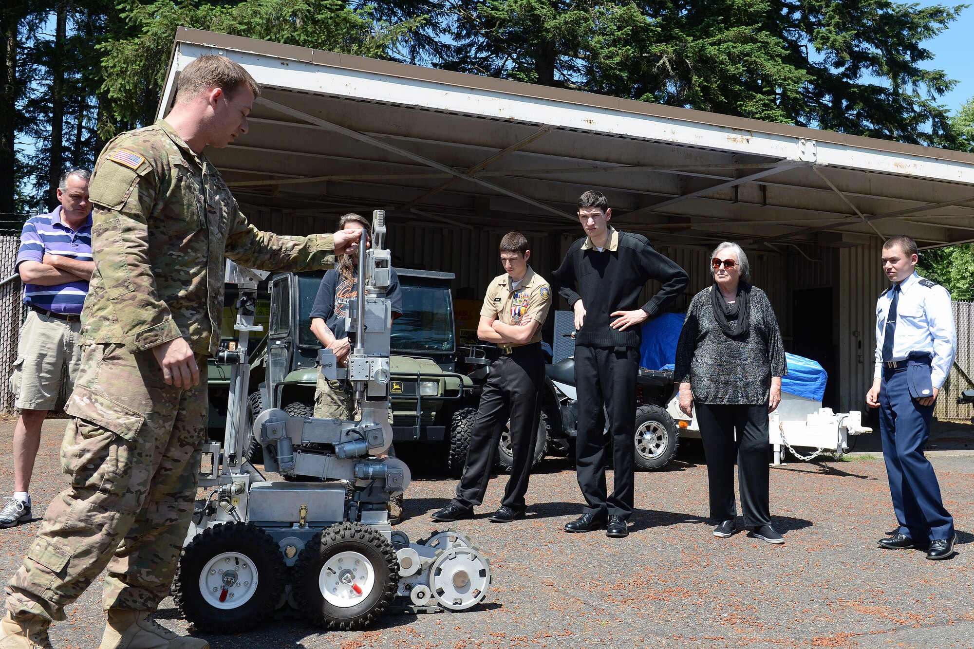 Staff Sgt. Paul Works (left), 627th Civil Engineer Squadron explosive ordnance disposal technician, shows and explains the importance of an explosive ordnance disposal robot to Junior ROTC award recipient cadets with their family and friends during a base tour May 31, 2014, at Joint Base Lewis-McChord, Wash. Cadets were able have some hands on experiences with equipment EOD uses out on the field. (U.S. Air Force photo/Senior Airmen Brenden Marlin)