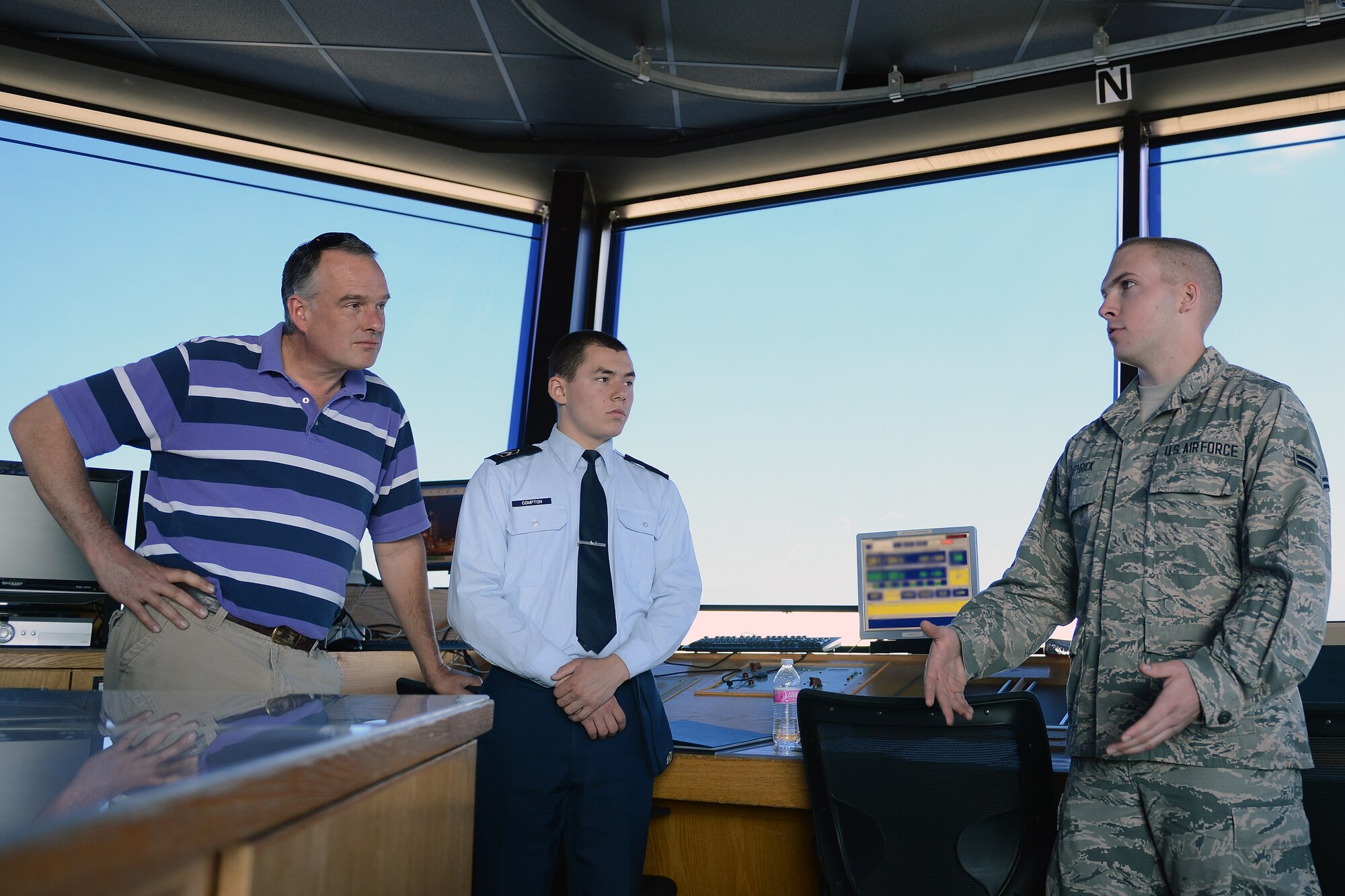 Airman 1st Class Austin Bathrick (right), 62nd Operations Support Squadron air traffic controller, answers questions about life in the Air Force and his responsibilities as an air traffic controller from Stanley Compton (center), Junior ROTC cadet, and his stepfather Curt Halson (left) May 31, 2014, at Joint Base Lewis-McChord, Wash. Junior ROTC cadets touring the base got to see and learn operations of air traffic controller as well as see test simulations. (U.S. Air Force photo/Senior Airmen Brenden Marlin)