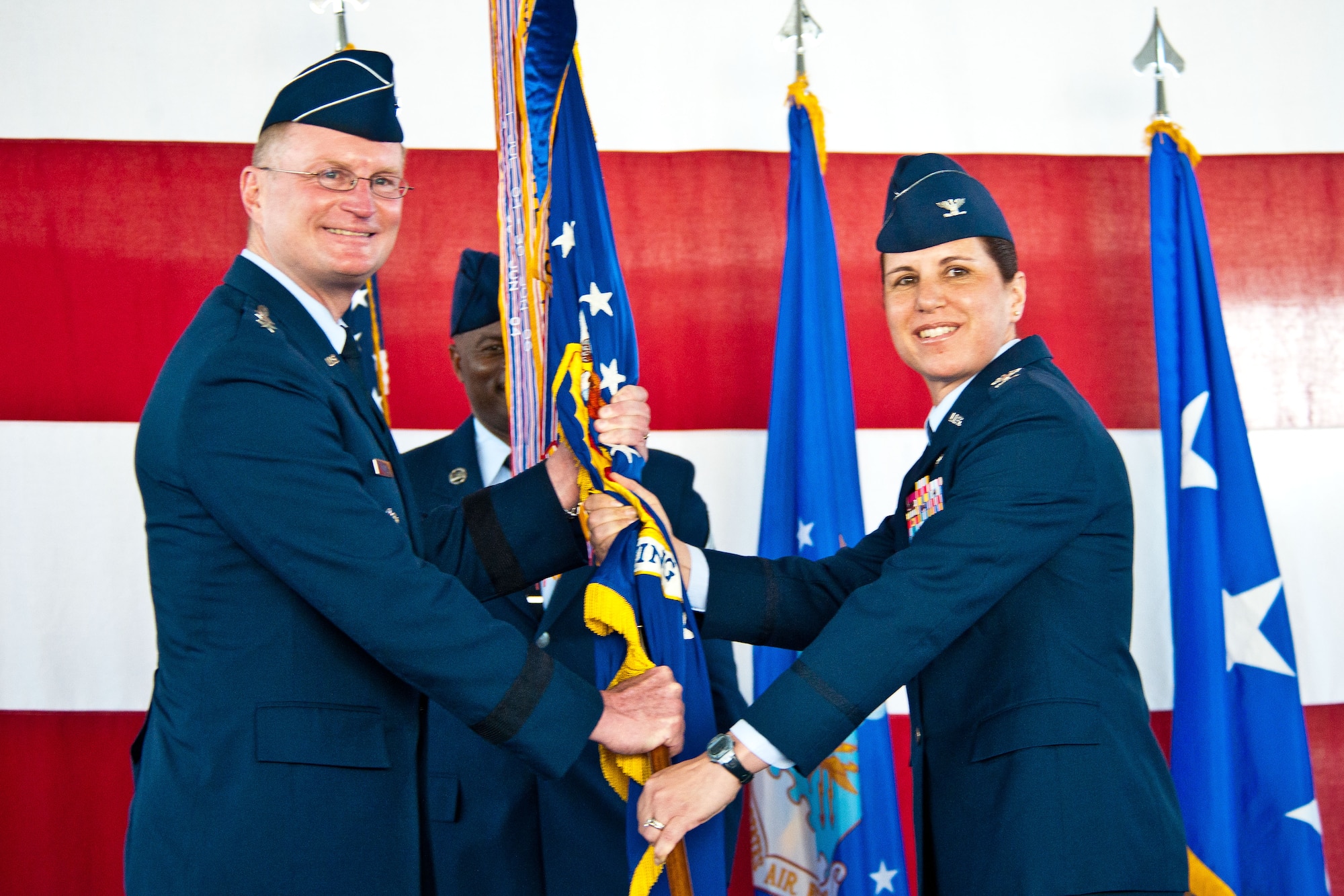 Lt. Gen. David Fadok, commander and president of Air University, hands the wing flag to , Col. Andrea Tullos, new commander for the 42nd Air Base Wing, during the change of command ceremony May 30. The colonel comes to Maxwell from the Pentagon, where she served as chief of the Arabian Peninsula and Iraq Division on the Joint Staff. (U.S. Air Force photo by Donna Burnett)