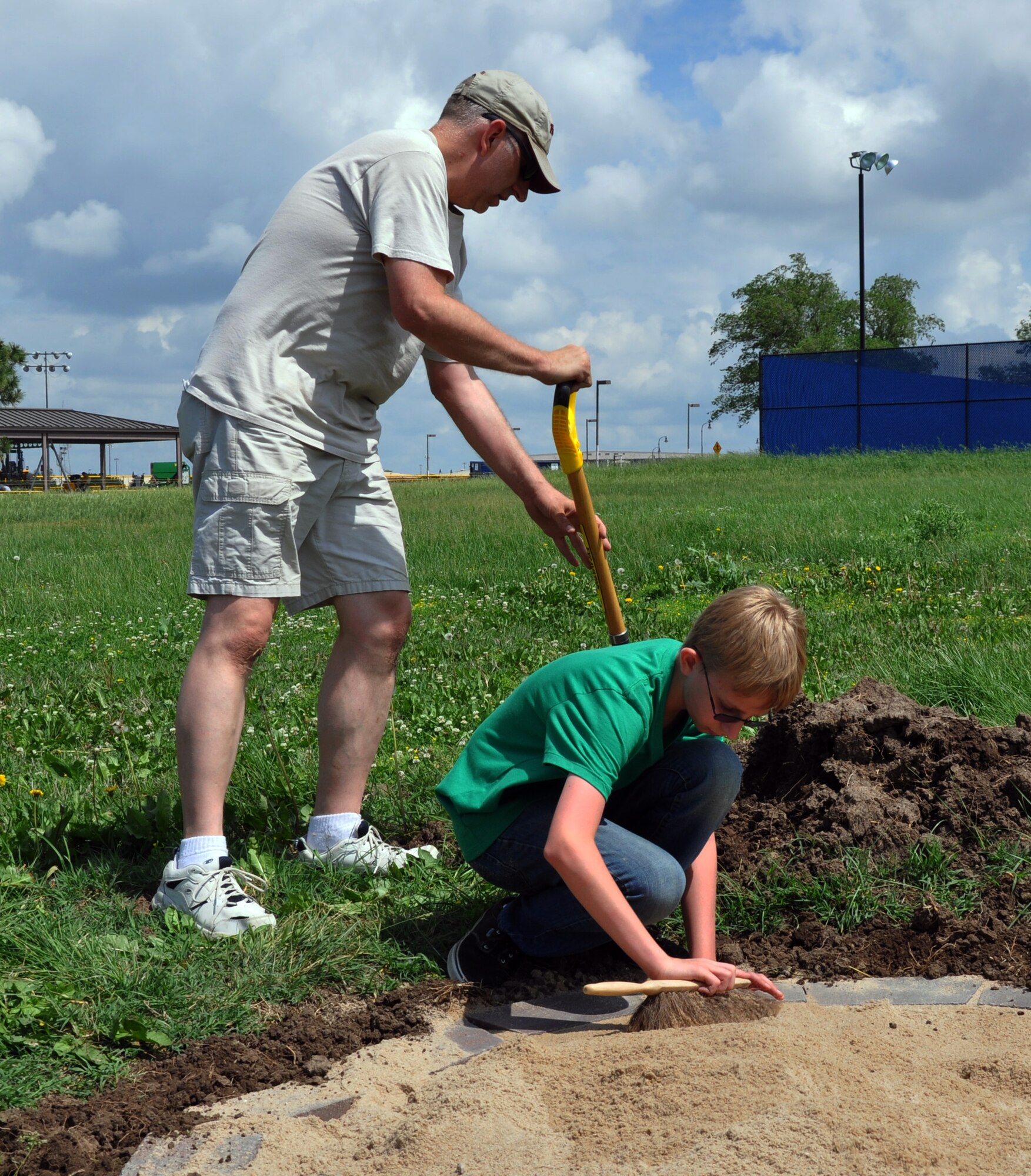 Master Sgt. Johnny Stephenson, 931st Air Refueling Group, works with his son, Taylor, to fill in sand for a disc golf tee box at McConnell Air Force Base, Kan., May 31, 2014.  Taylor has been working on a volunteer project to redesign and install a new disc golf course at the base as part of his Eagle Scout project through the Boy Scouts organization.  The new course will feature nine new disc golf holes with improved regulation tee boxes.  (U.S. Air Force photo by Capt. Zach Anderson)