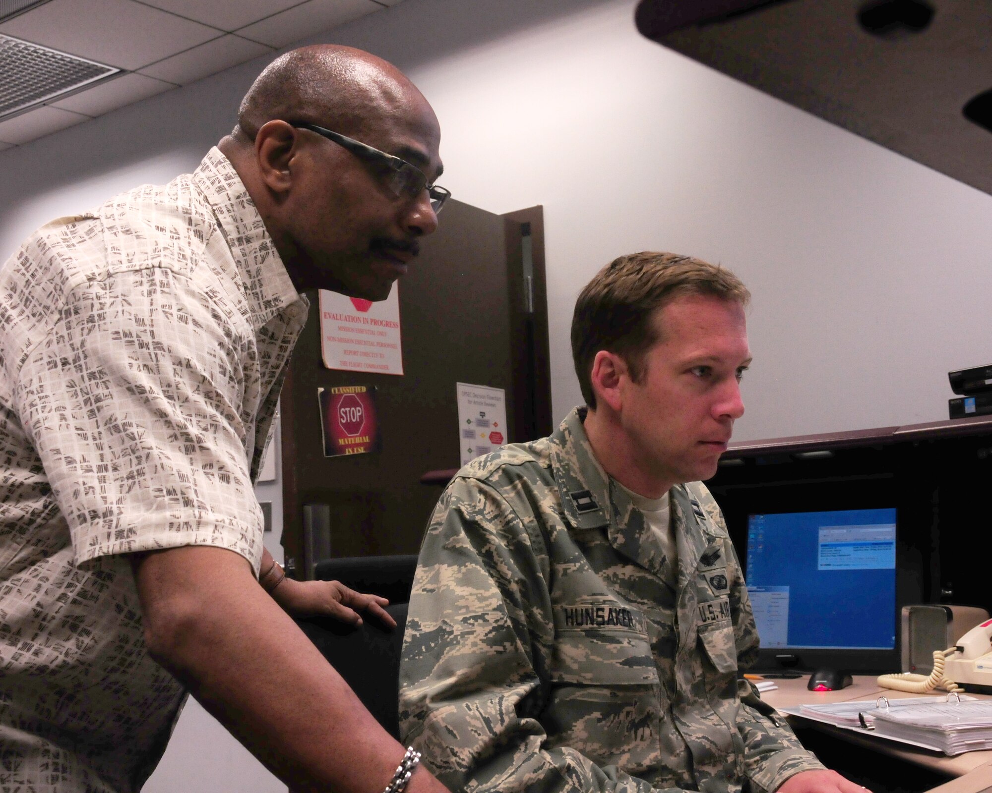 Air Force Reserve Capt. Tom Hunsaker, 6th Space Operations Squadron satellite systems operator, and Lindsey Williams, National Oceanic and Atmospheric Administration shift supervisor, perform ground troubleshooting prior to satellite contact during an annual Continuity of Operations Plan at Schriever AFB, Colo.  The COOP exercise provides military and civilian operators a chance to exchange new ideas, techniques and procedures, and enhance operations at facilities in Suitland, Md., and Schriever AFB. (U.S. Air Force photo/Tech. Sgt. Jeff Fitzmorris)